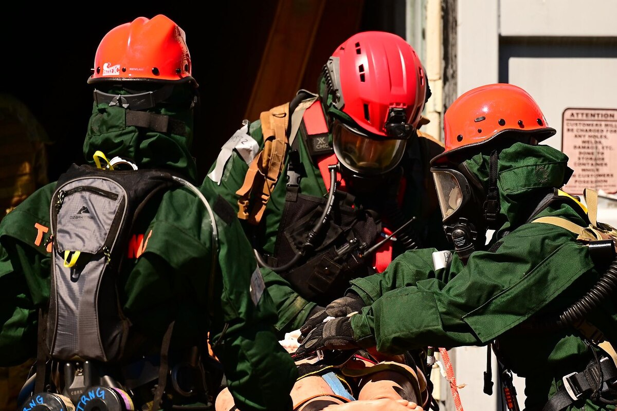 Search and extraction team members including U.S. Air Force Tech. Sgt. Samuel Marchini, center, of the 144th Medical Detachment, 144th Fighter Wing, California Air National Guard, and Spc. Karen Noyes, right, a heavy equipment construction mechanic with the 649th Engineer Company, 49th Military Police Brigade, California Army National Guard, place a mannequin on a litter and evaluate the simulated patient's injuries after pulling the victim out of a collapsed building during an exericse at Camp Roberts March 30, 2023.