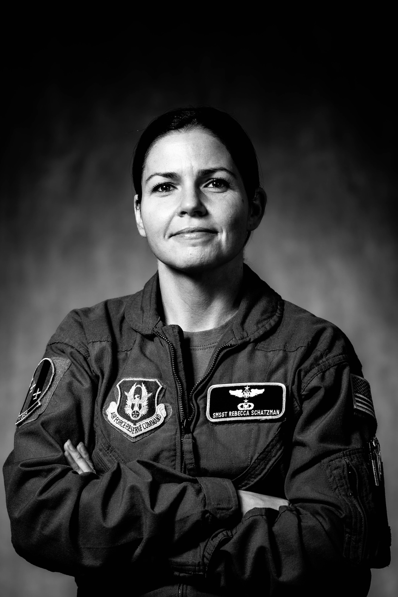 Senior Master Sgt. Rebecca Schatzman poses for a black and white portrait on a gray background