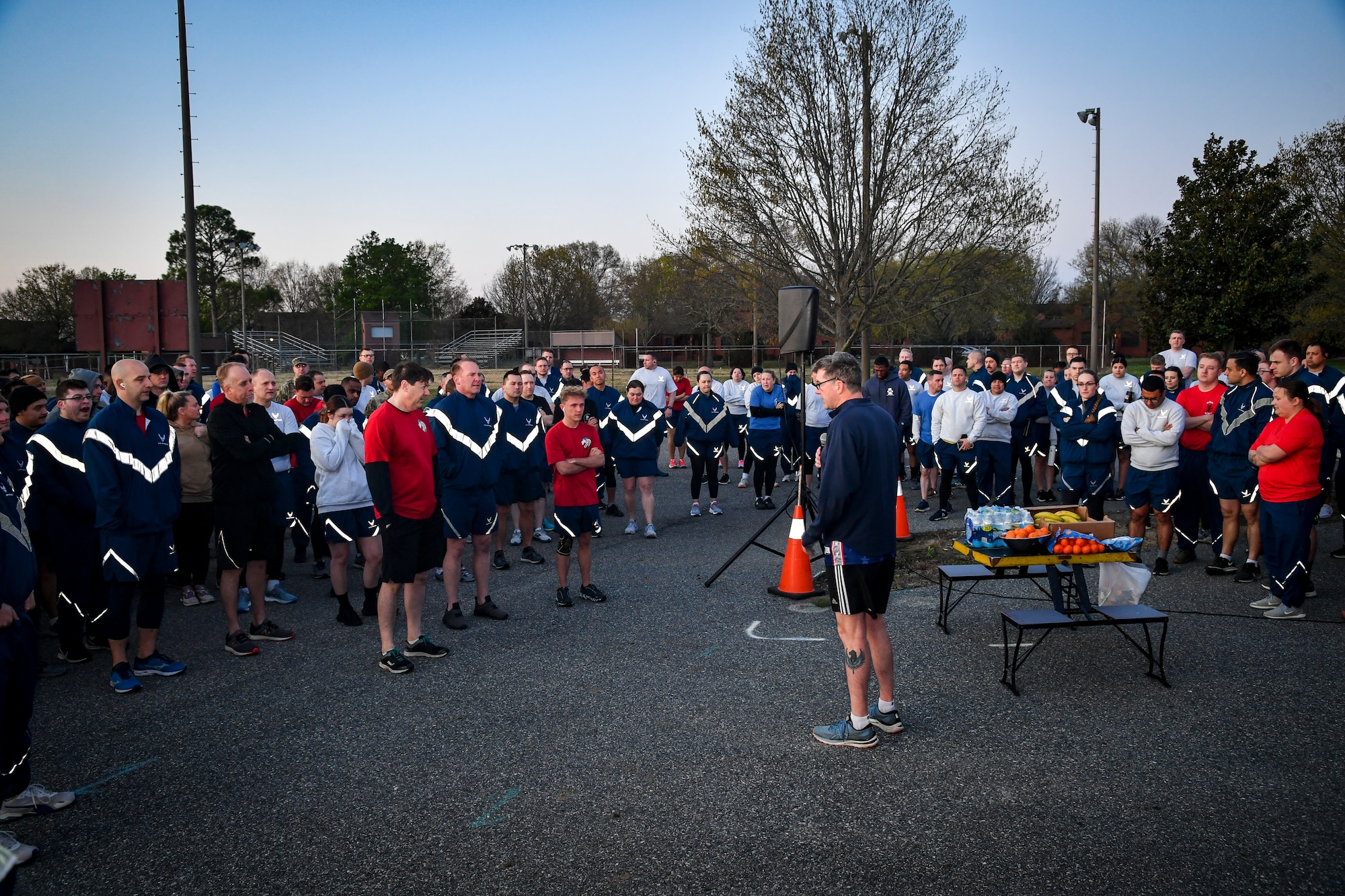 Runners huddle up and listen to a speaker.