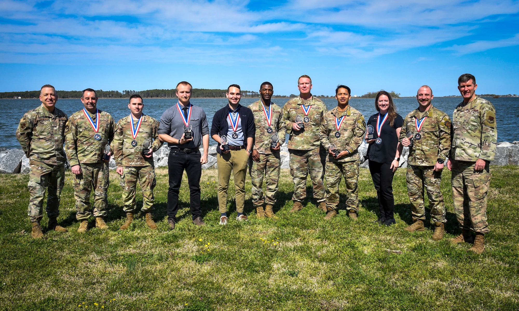 A group of people pose with awards in their hands.