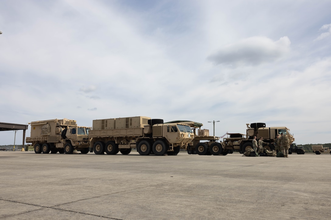 U.S. Soldiers assigned to Battery B and Company E, 1st Battalion, 7th Air Defense Artillery stationed at Fort Bragg, North Carolina, are staged near an airfield awaiting a C-17 Globemaster III, assigned to 16th Airlift Squadron, Charleston Air Force Base, South Carolina, during exercise Operation Panther Talon at Marine Corps Air Station (MCAS) Cherry Point, North Carolina, March 31, 2023. MCAS Cherry Point’s training facilities, special-use air space, and proximity to Fort Bragg and Seymour Johnson Air Force Base allows the execution of expeditionary deployment operations to maintain and ensure mission readiness and strengthen joint service relations. (U.S. Marine Corps photo by Lance Cpl. Lauralle Walker)