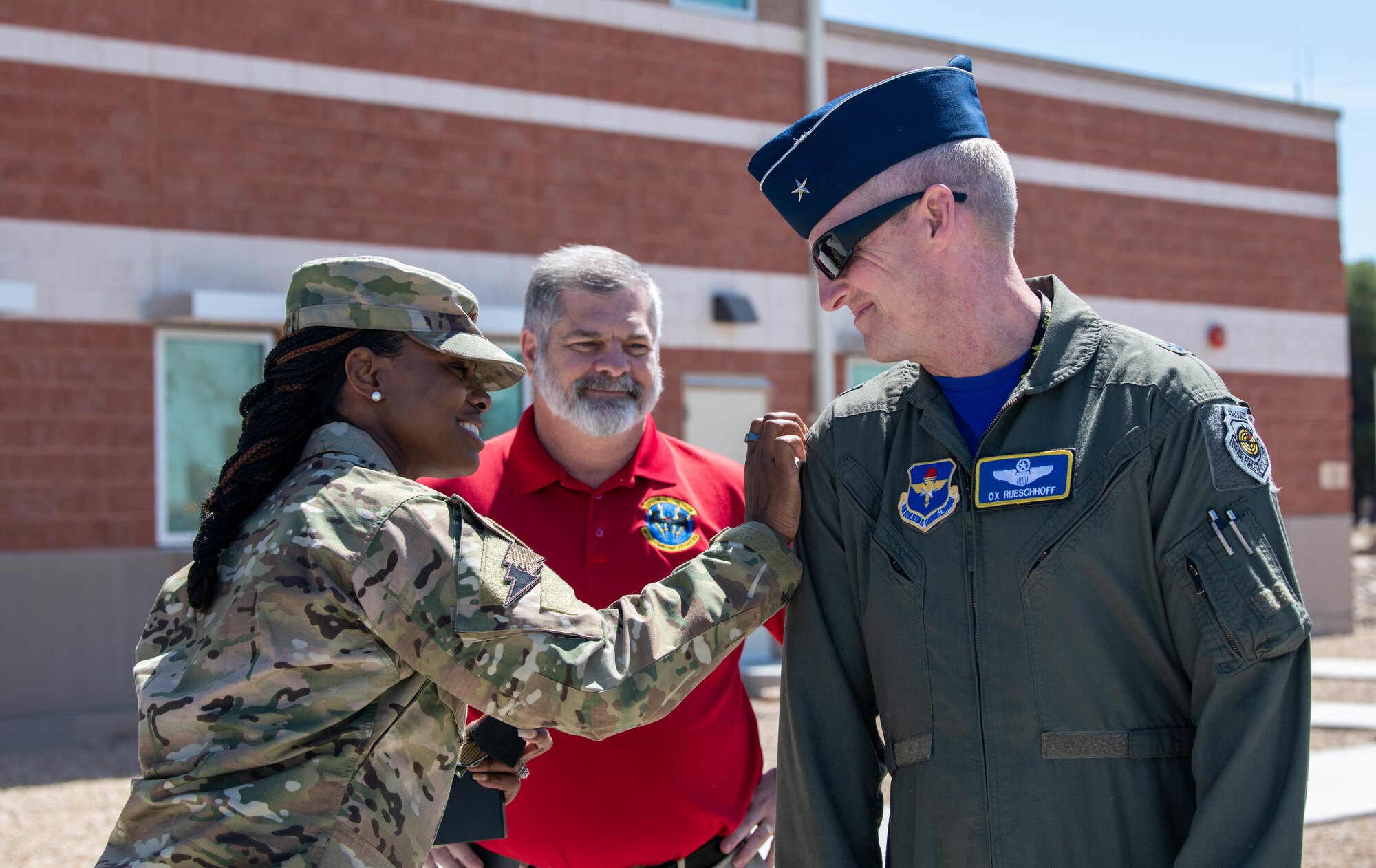 U.S. Air Force Maj. Ashley Lopez-Clark, 56th Communications Squadron commander, places a squadron patch on Brig. Gen. Jason Rueschhoff, 56th Fighter Wing commander, March 31, 2023, at Luke Air Force Base, Arizona.