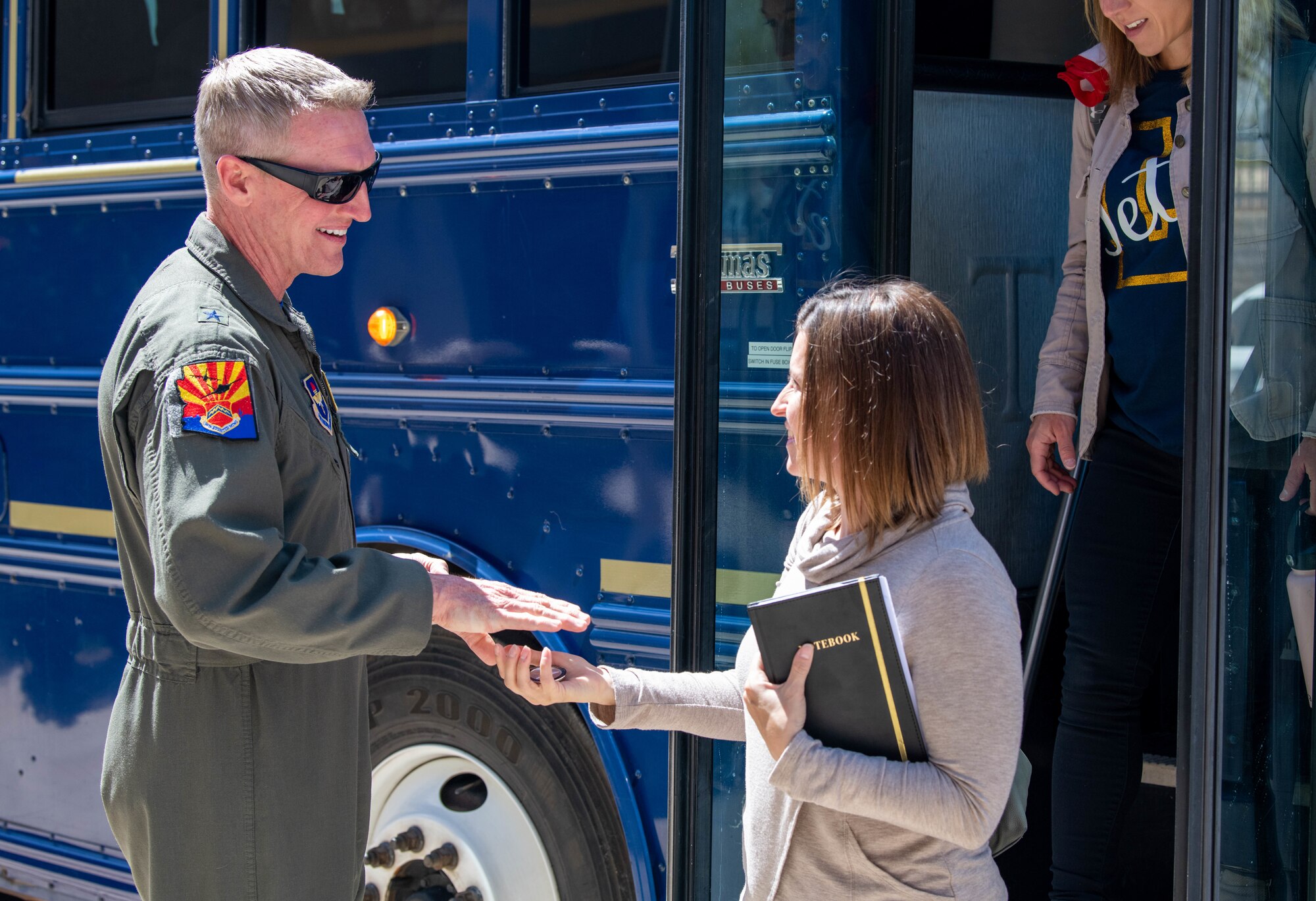U.S. Air Force Brig. Gen. Jason Rueschhoff, 56th Fighter Wing commander, coins Michelle Hill, Dreaming Summit Elementary School principal, during the West Valley Educators Immersion Tour, March 31, 2023, at Luke Air Force Base, Arizona.