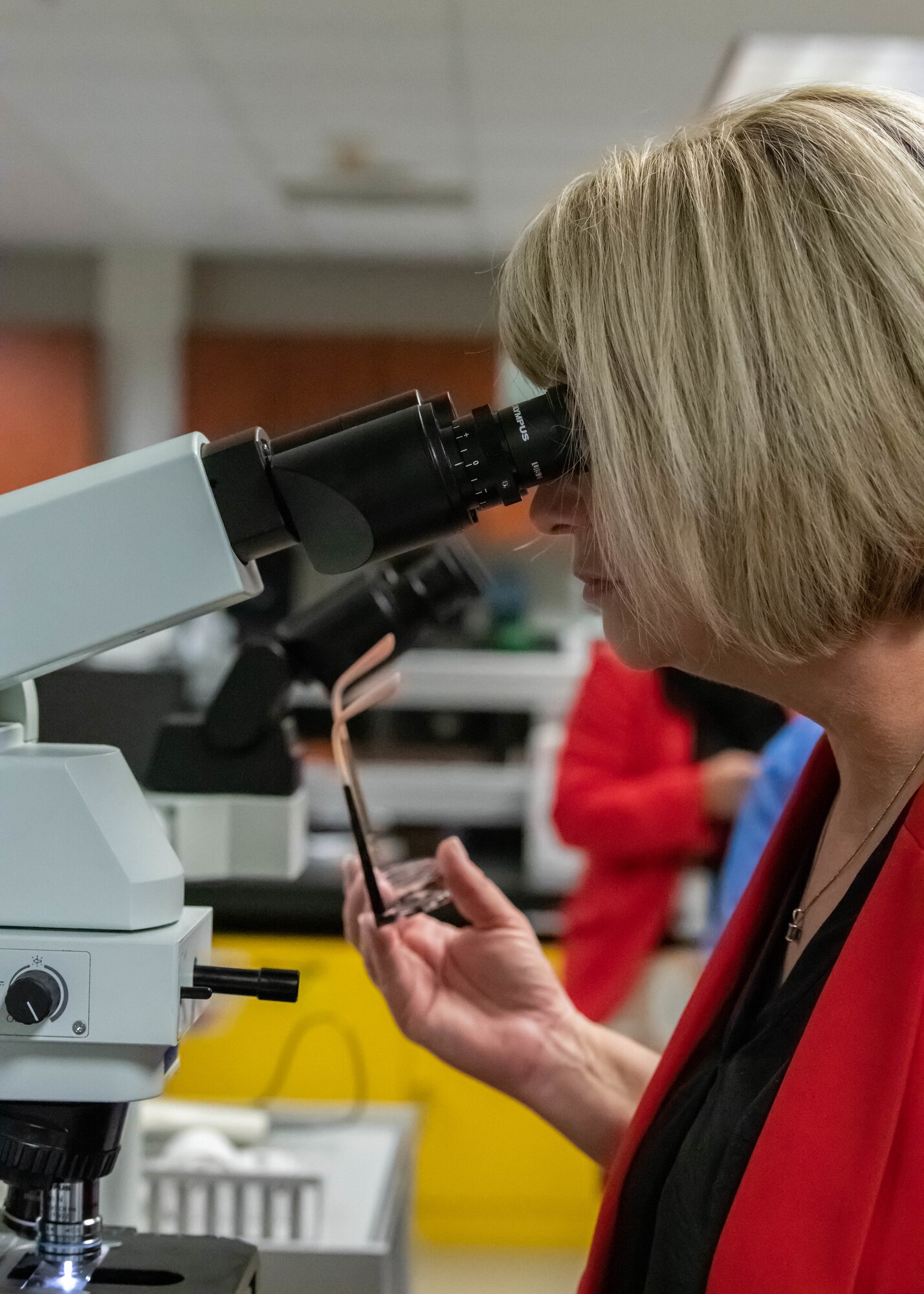 Brandi Haskans, La Joya Community High School principal, looks into a microscope at the medical treatment facility during the West Valley Educators Immersion Tour, March 31, 2023, at Luke Air Force Base, Arizona.