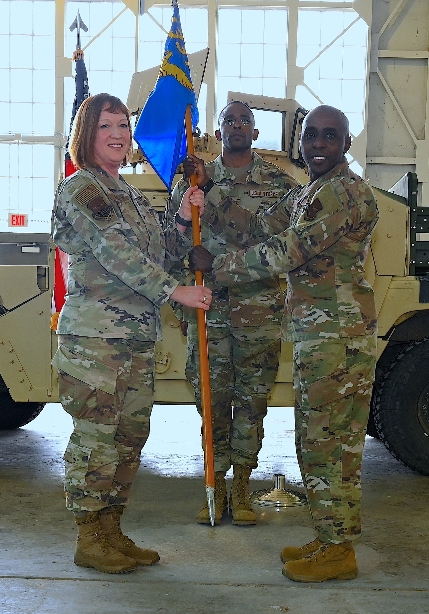 Col. Jeanne Bisesi, 433rd Mission Support Group commander, presents the 433rd Civil Engineer Squadron guidon to Maj. Bernard Wesley during an assumption of command ceremony at Joint Base San Antonio-Lackland, Texas, April 1, 2023.