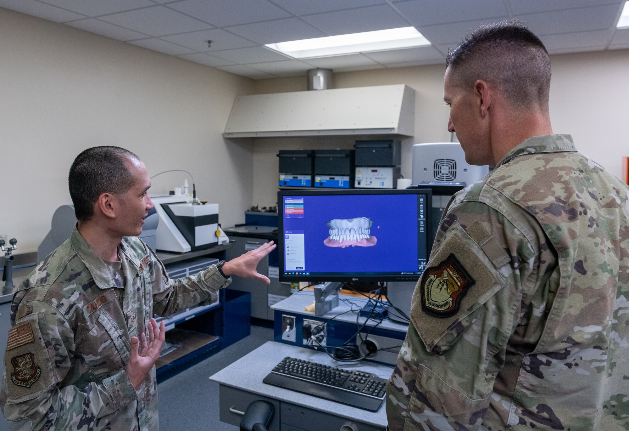 U.S. Air Force Tech. Sgt. Jan Michael Cancio, 81st Dental Squadron dental lab flight chief, briefs Col. Billy Pope, 81st Training Wing commander, on dental lab equipment during the 81st Medical Group Immersion Tour inside the Keesler Medical Center at Keesler Air Force Base, Mississippi, April 3, 2023.