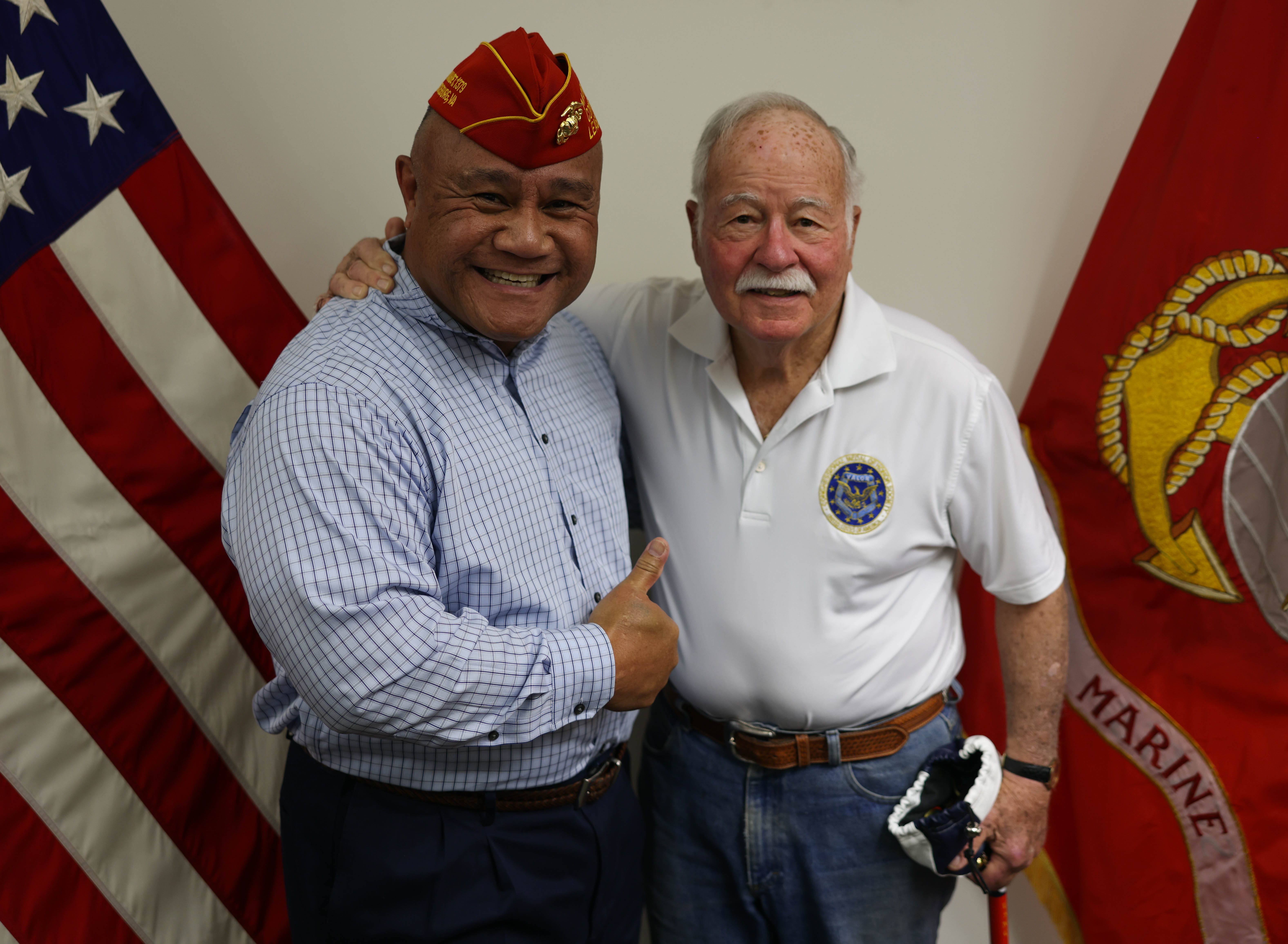 Two men with their arms around each other, the left is a recipient of the Medal of Honor, the right is a retired Marine.