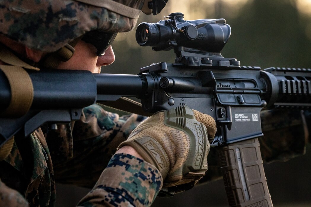 Close up of a Marine looking down the scope of a gun.