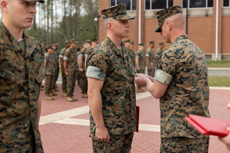 U.S. Marine Corps Corporal John Darby, a flight equipment technician attending Marine Security Guard School at Marine Corps Embassy Security Group, receives the Navy and Marine Corps Achievement Medal from Lt. Col. Matthey McNerney, the executive officer of Marine Corps Embassy Security Group,  for heroic acts performed while off-duty during an awards ceremony on Quantico, Virginia, April 6, 2023. Darby and two other Marines received the award after intervening during an altercation between civilians involving a knife. The Marines successfully deescalated the situation, recovered the weapon and restrained the perpetrators until the police arrived on scene. (U.S. Marine Corps photos by Cpl. Keegan Bailey)