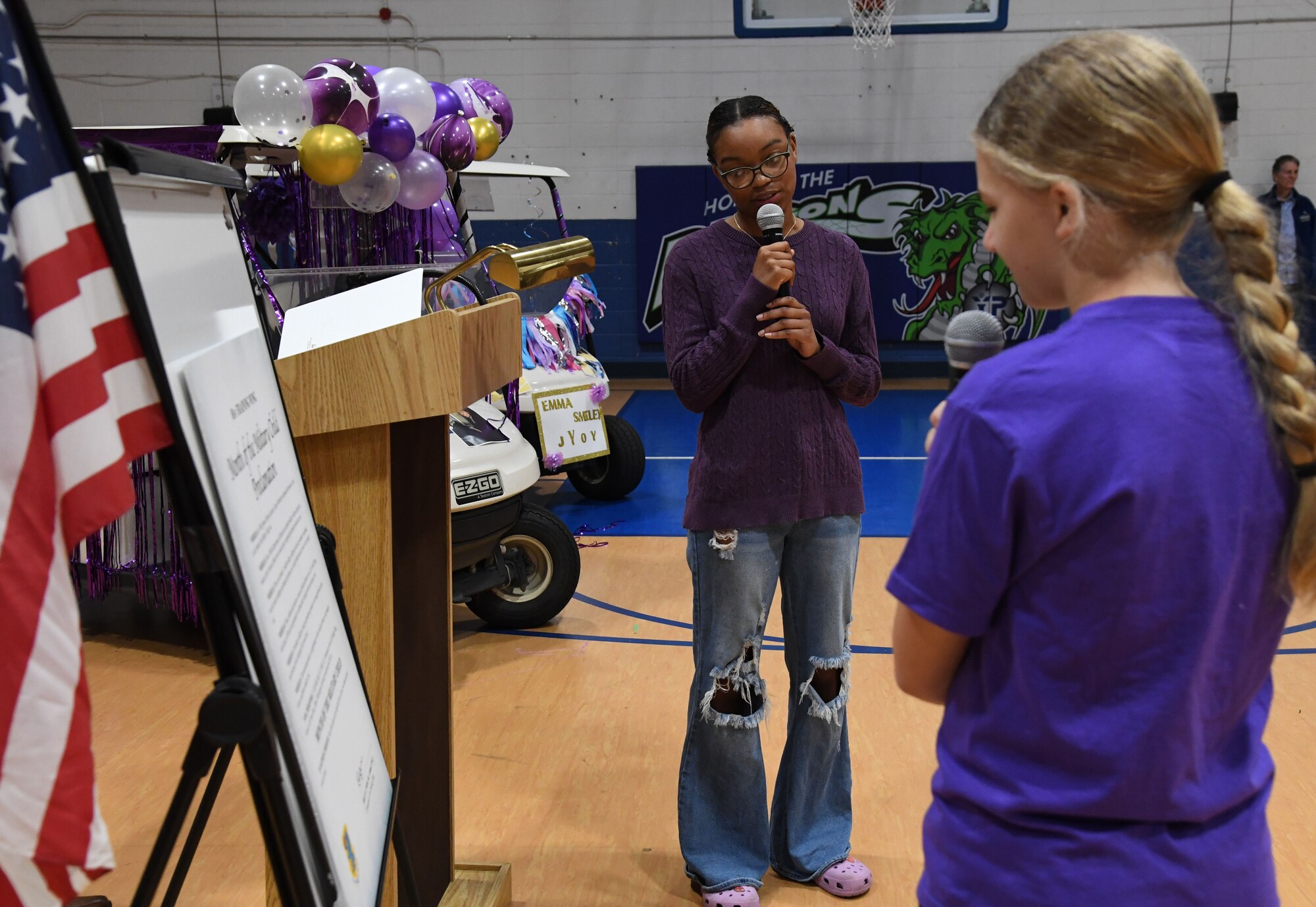Keyana Gales-Cook, daughter of U.S. Navy Petty Officer 1st Class Herbert Wells, Naval Construction Battalion Center, Gulfport, Mississippi, and Emma Smiley, daughter of U.S. Air Force Maj. Joseph Smiley, 335th Training Squadron director of operations, reads the Month of the Military Child Proclamation during a pep rally inside the Youth Center at Keesler Air Force Base, Mississippi, April 7, 2023.