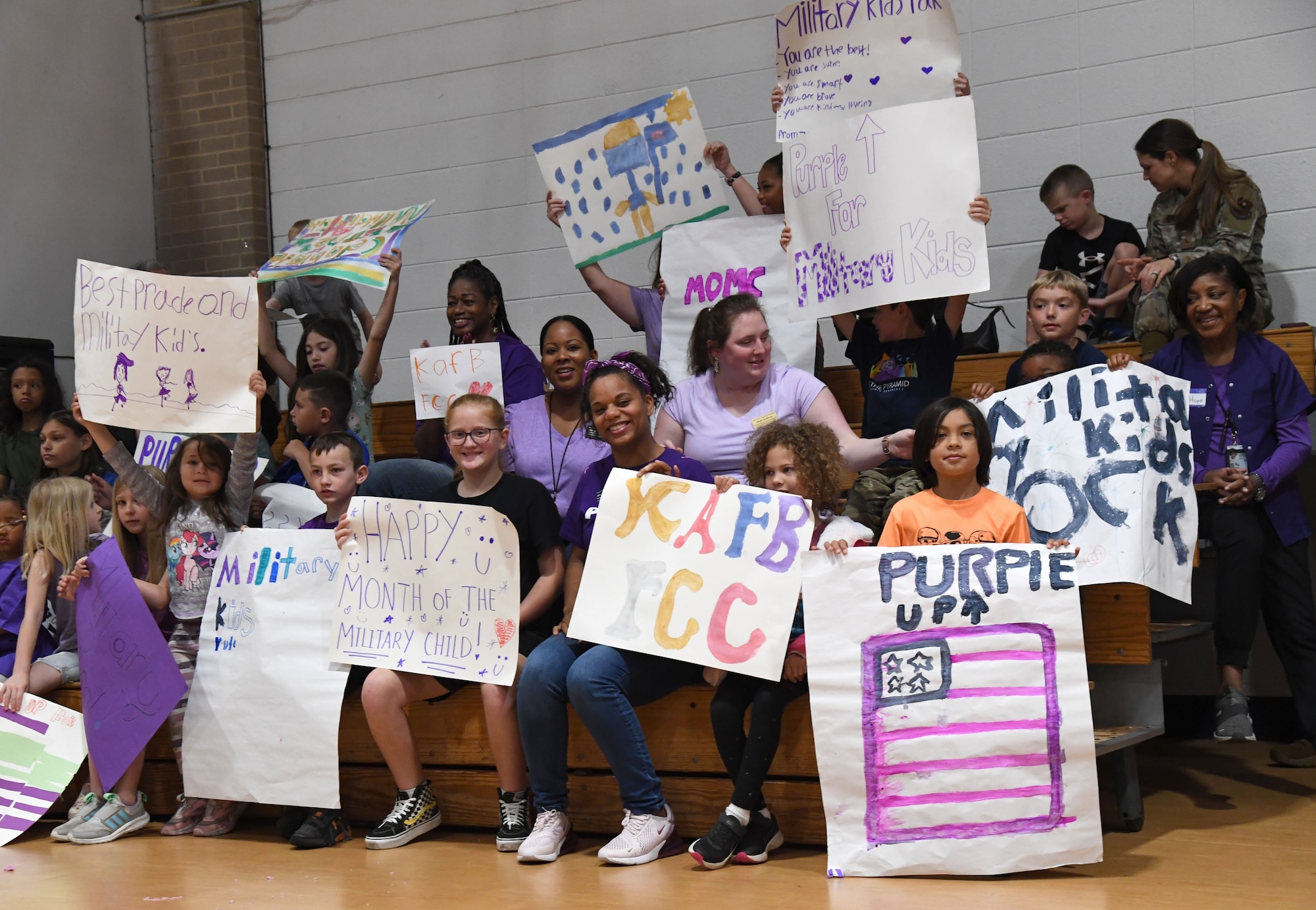 Keesler children display posters during a pep rally inside the Youth Center at Keesler Air Force Base, Mississippi, April 7, 2023.