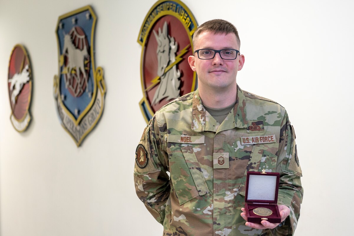 U.S. Air Force Master Sgt. Paul Noel, an intelligence specialist for the 167th Operations Support Squadron, displays a coin from the Qatar Armed Forces at the 167th Airlift Wing, Martinsburg, West Virginia, April 1, 2023.
