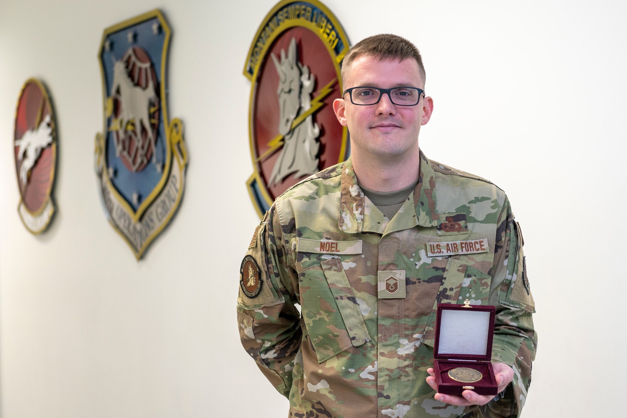 U.S. Air Force Master Sgt. Paul Noel, an intelligence specialist for the 167th Operations Support Squadron, displays a coin from the Qatar Armed Forces at the 167th Airlift Wing, Martinsburg, West Virginia, April 1, 2023.