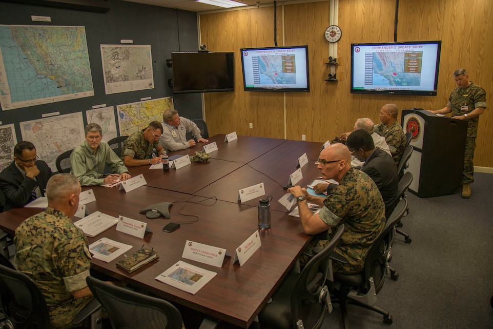 U.S. Marine Corps Lt. Col. Alexander H. Miller, senior watch officer, Marine Corps Installations West, Marine Corps Base, Camp Pendleton, far right, gives the 'Commander's Update Brief' to U.S. Marine Corps Brig. Gen. Kevin J. Killea, commanding general, MCIWEST-MCB, Camp Pendleton, during exercise Semper Durus 17 on Camp Pendleton, Calif., April 13, 2017. Semper Durus is a regional command post exercise and is comprised of a series of field training scenarios designed to improve regional command and control, enhance interagency coordination, and improve installation capabilities to respond to, and recover from, a crisis event and validate the installation mission assurance all-hazard plan.