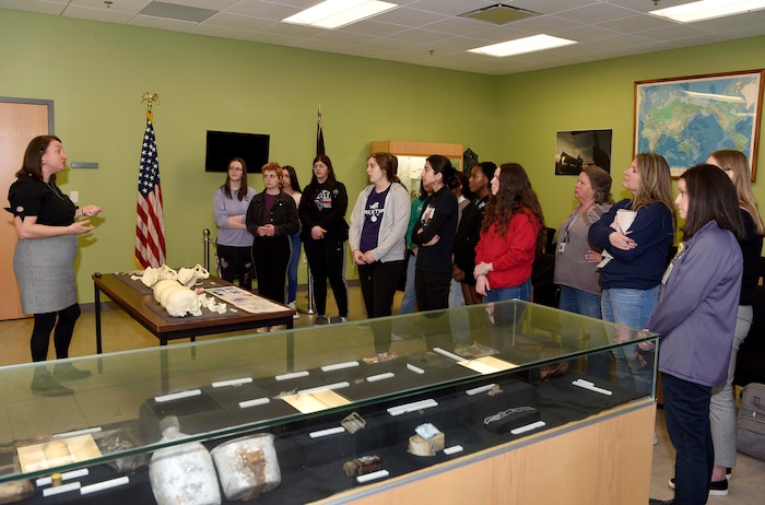 Woman talks to group of teenage girls and their adult chaperones