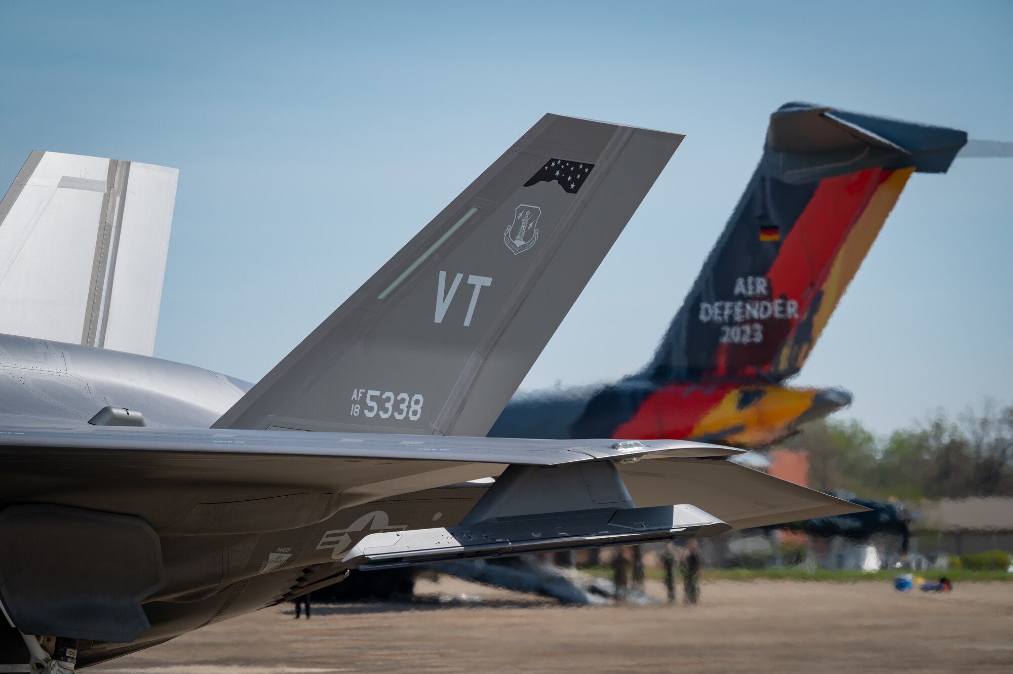 A F-35A Lightning II assigned to the 158th Fighter Wing, Vermont National Guard, taxis by a German Air Force Airbus A400M-180 painted with Air Defender 2023 decals during a media event highlighting Air Defender 2023 on the flight line at Joint Base Andrews, Maryland, April 5, 2023.