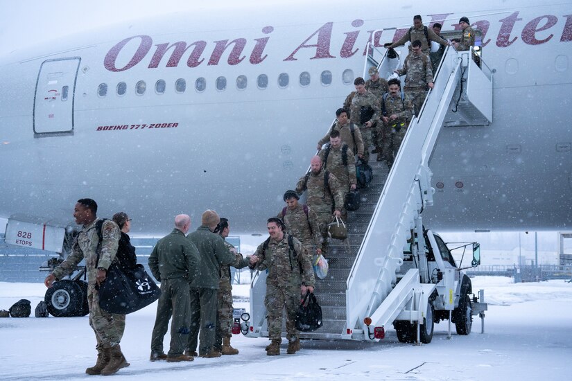 Airmen descend stairs placed outside their jet