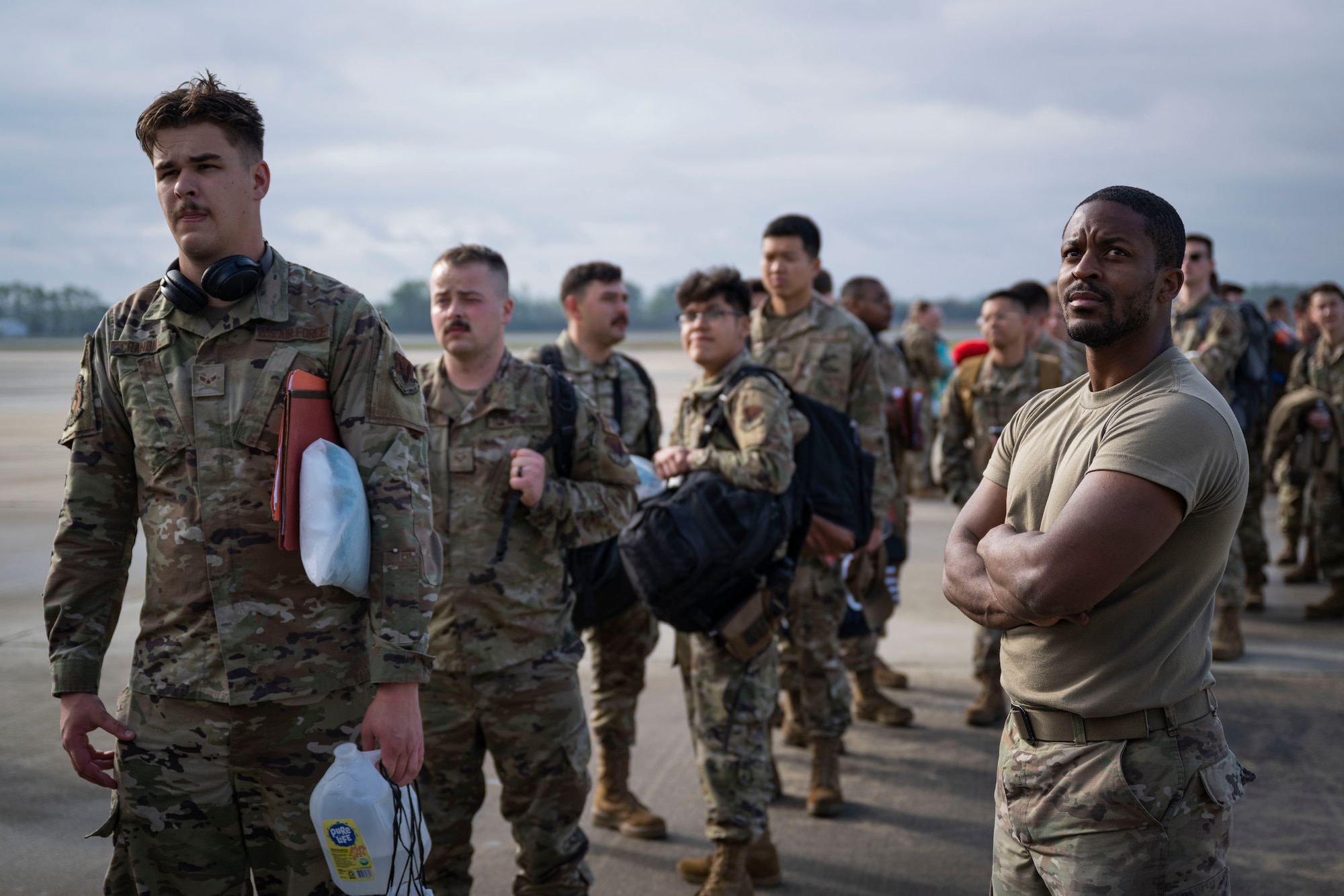 Airmen wait in line to board an aircraft.