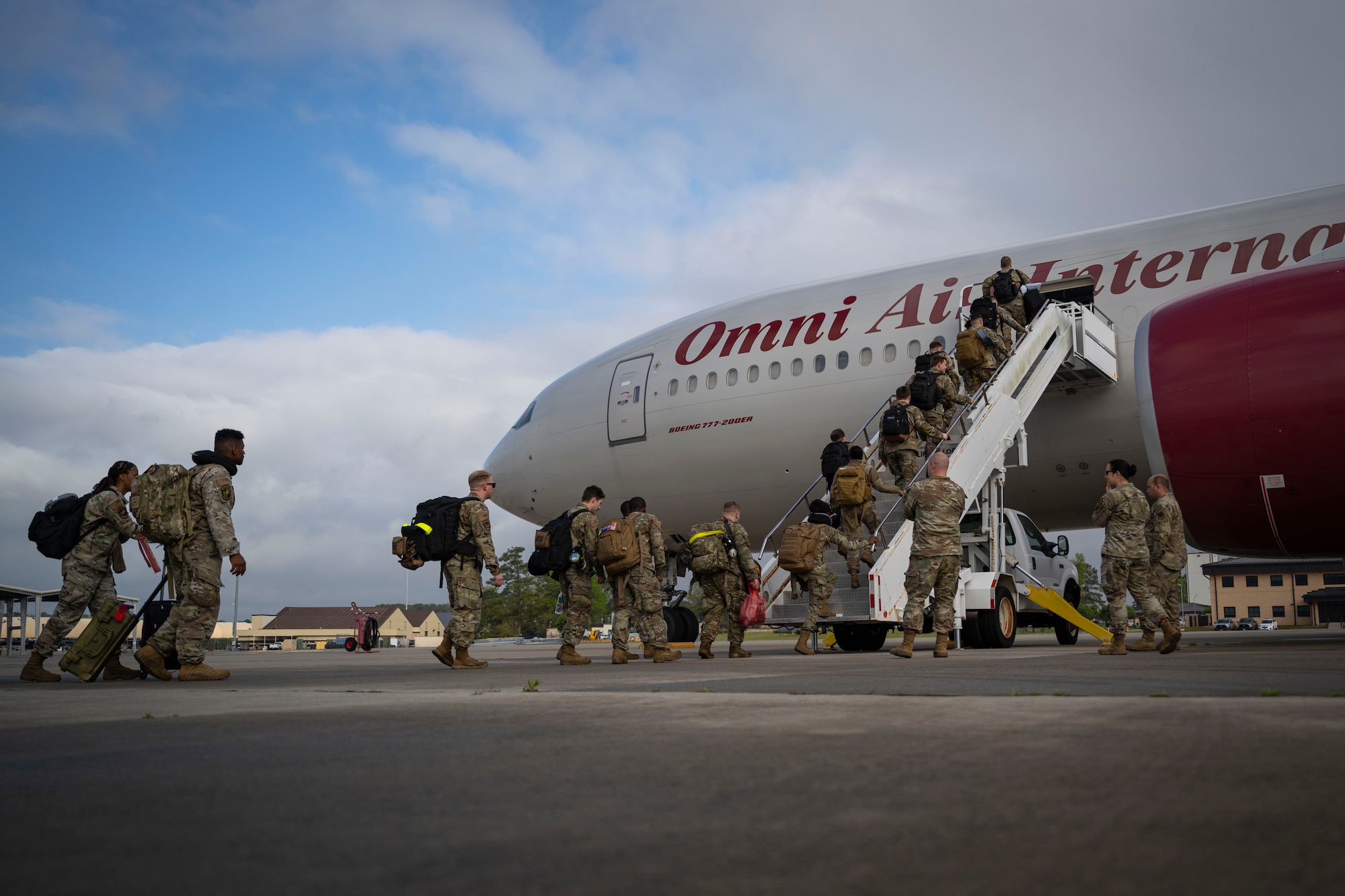 Airmen board an aircraft to deploy.