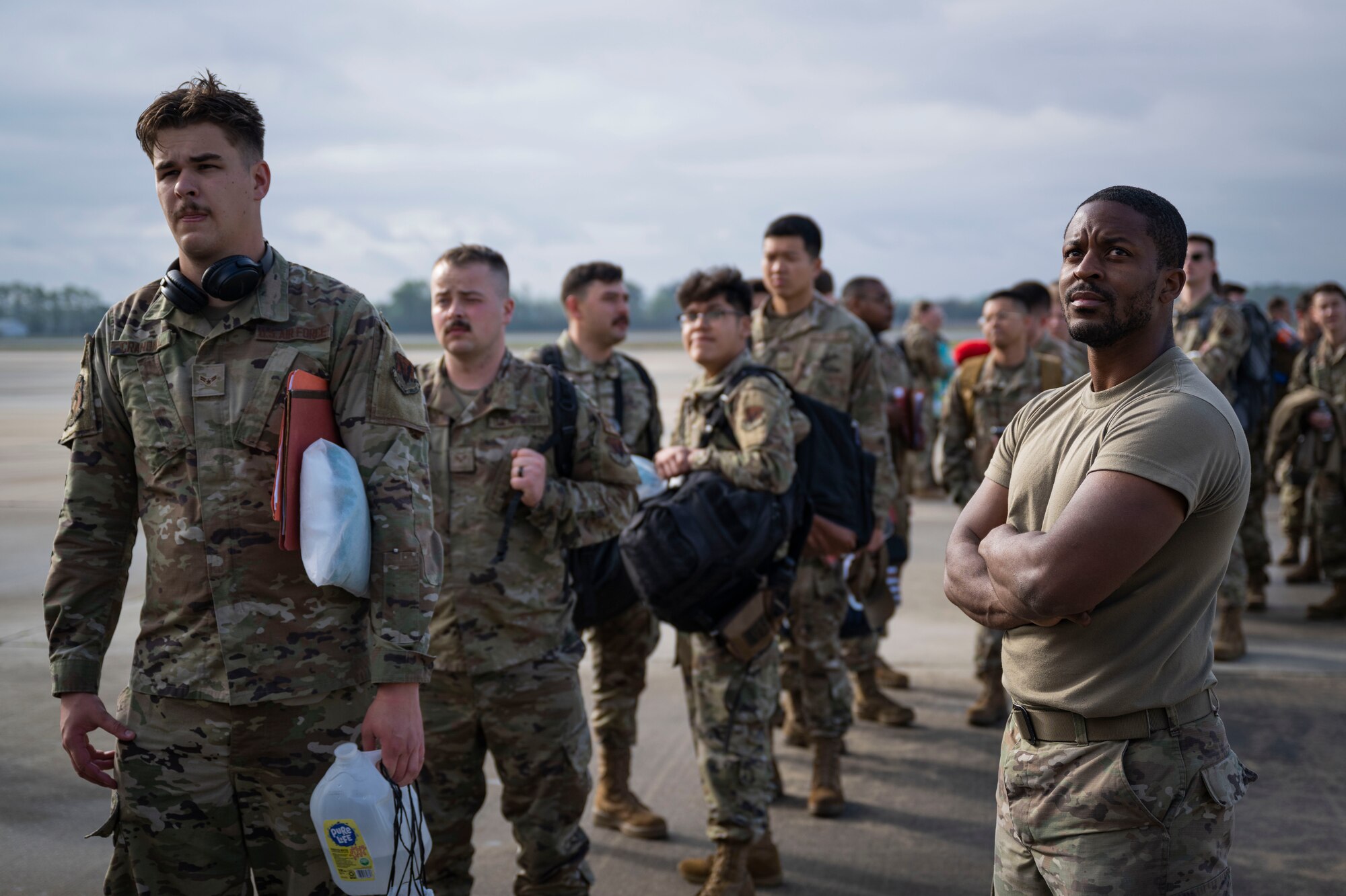 Airmen wait in line to board an aircraft.