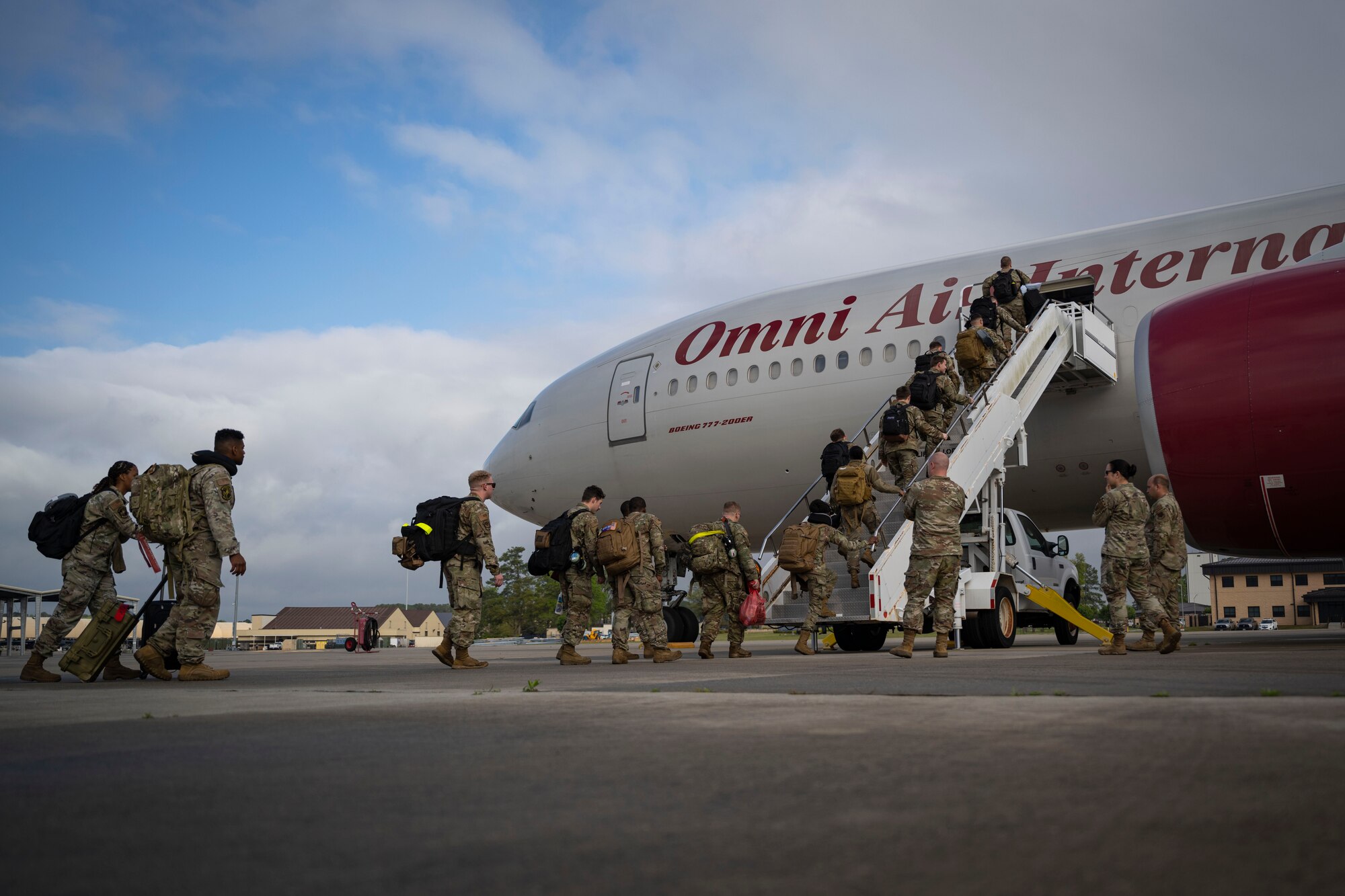 Airmen board an aircraft to deploy.