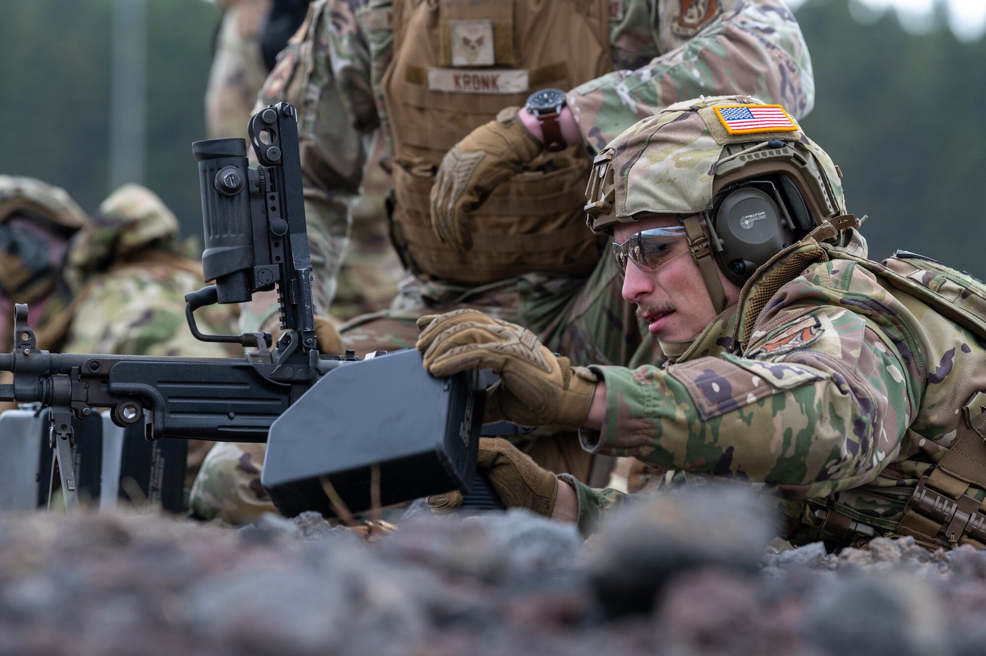A service member removes the magazine of an M249 Squad Automatic Weapon during a sustainment firing.