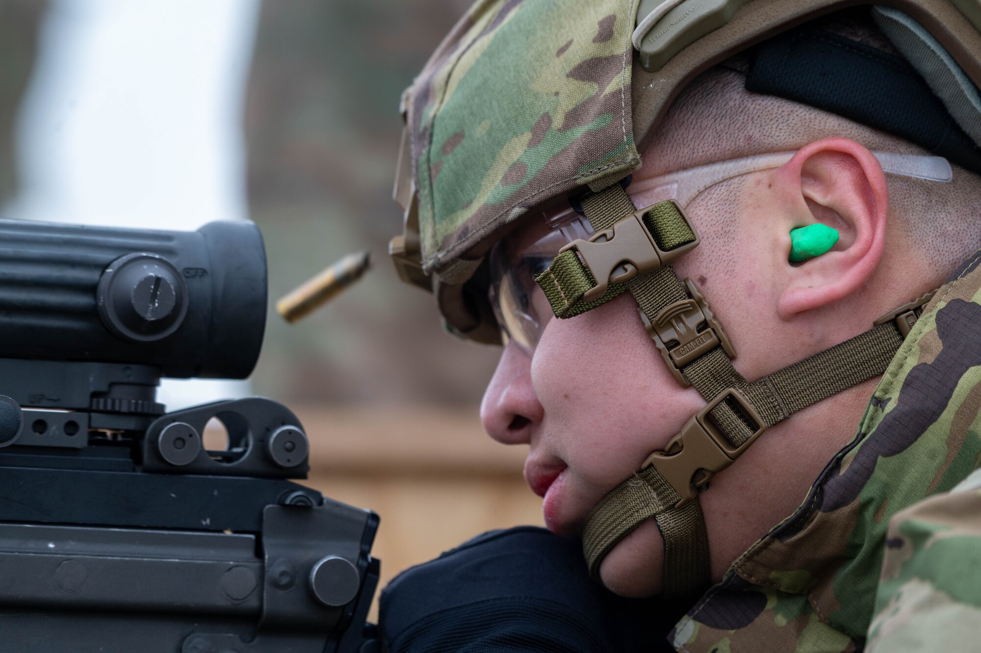 A service member focuses on hitting his target during an M249 Squad Automatic Weapon sustainment firing.