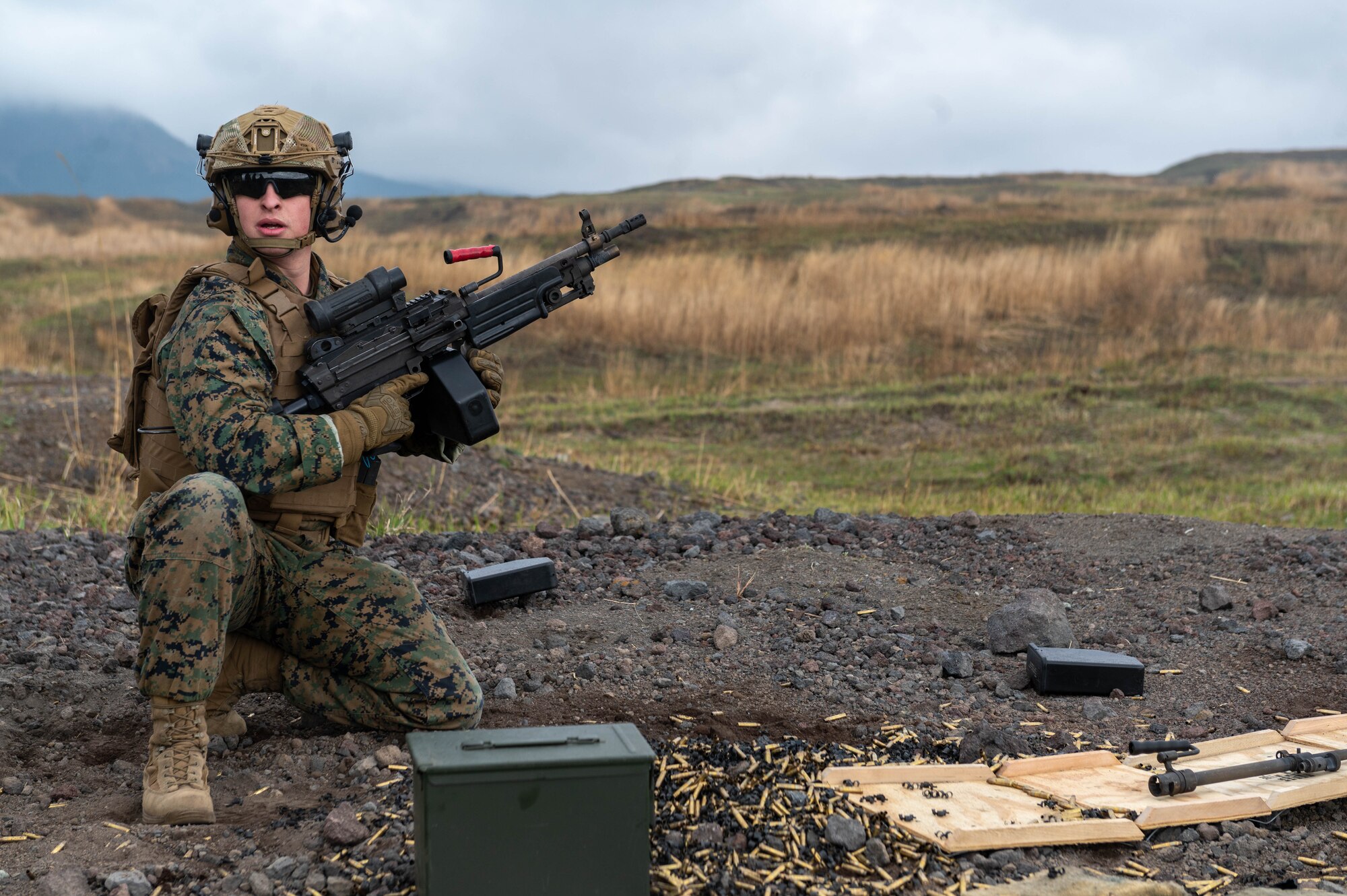 A service member holds an M249 Squad Automatic Weapon.