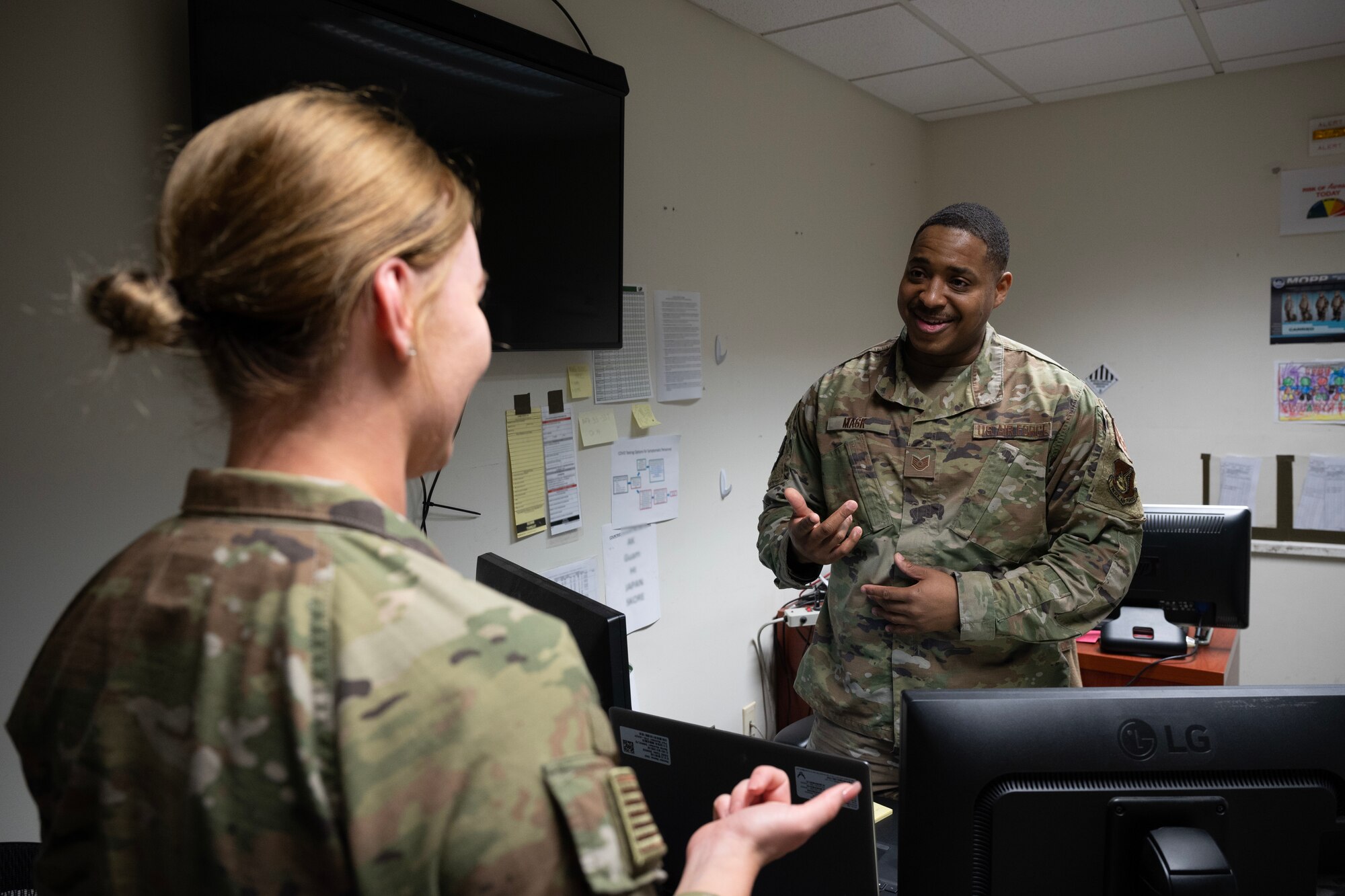 An Airman asks another Airman a question and the second Airman answers.