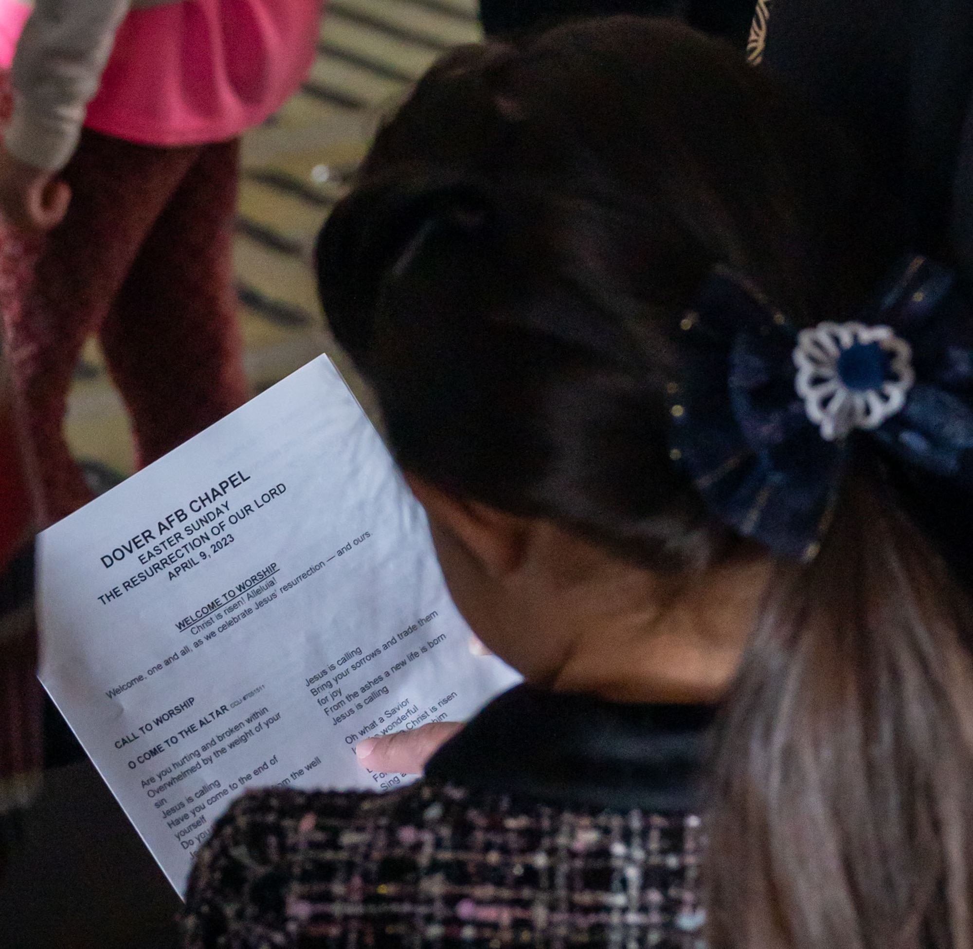 A Team Dover member reads a program pamphlet during a religious service aboard a C-5M Super Galaxy at Dover Air Force Base, Delaware, April 9, 2023. For the first time since the COVID-19 pandemic, the 436th Airlift Wing Chapel team hosted 130 Team Dover members aboard a C-5 for a religious service. (U.S. Air Force photo by Airman 1st Class Amanda Jett)