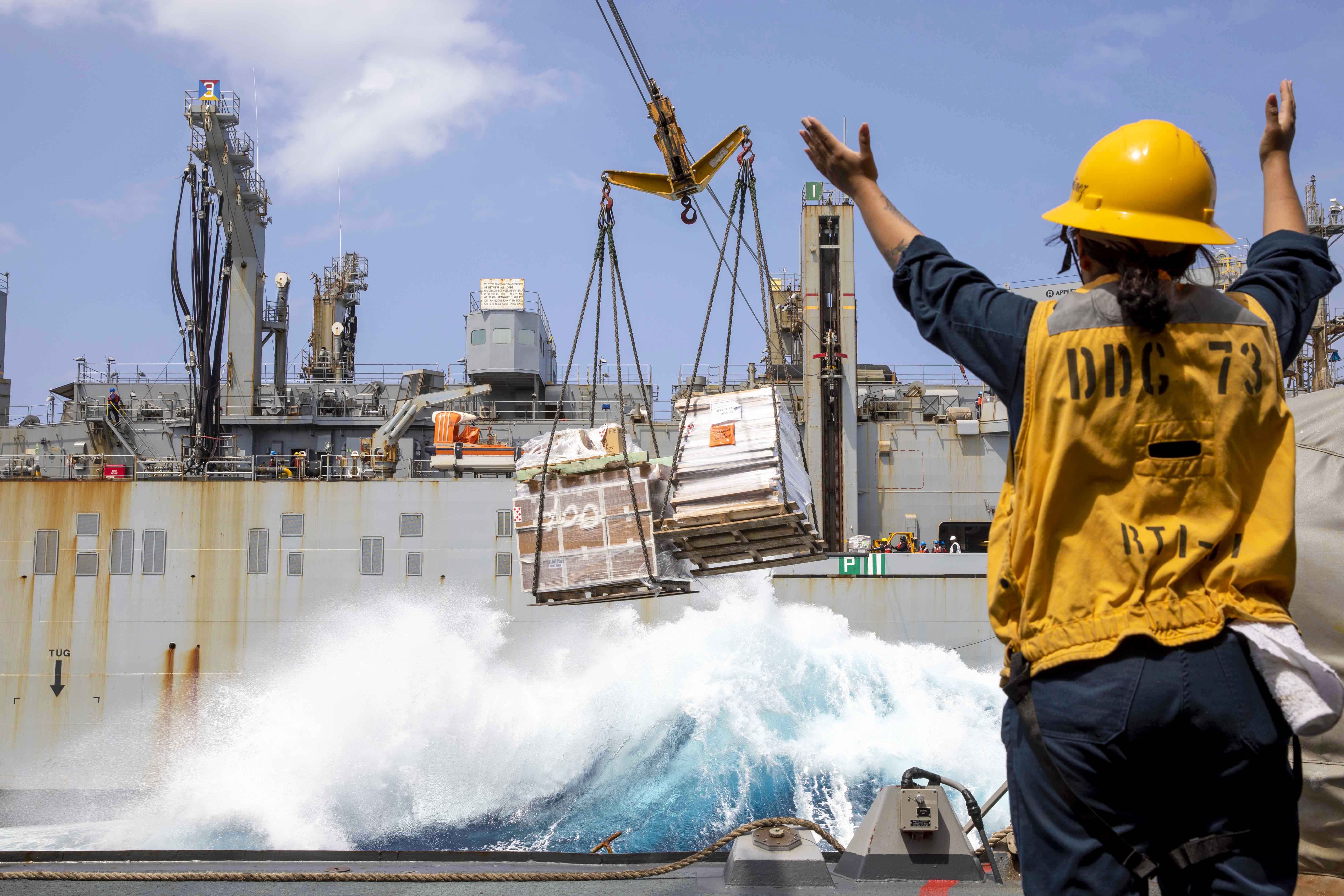 An officer directs a shipment in the harbor