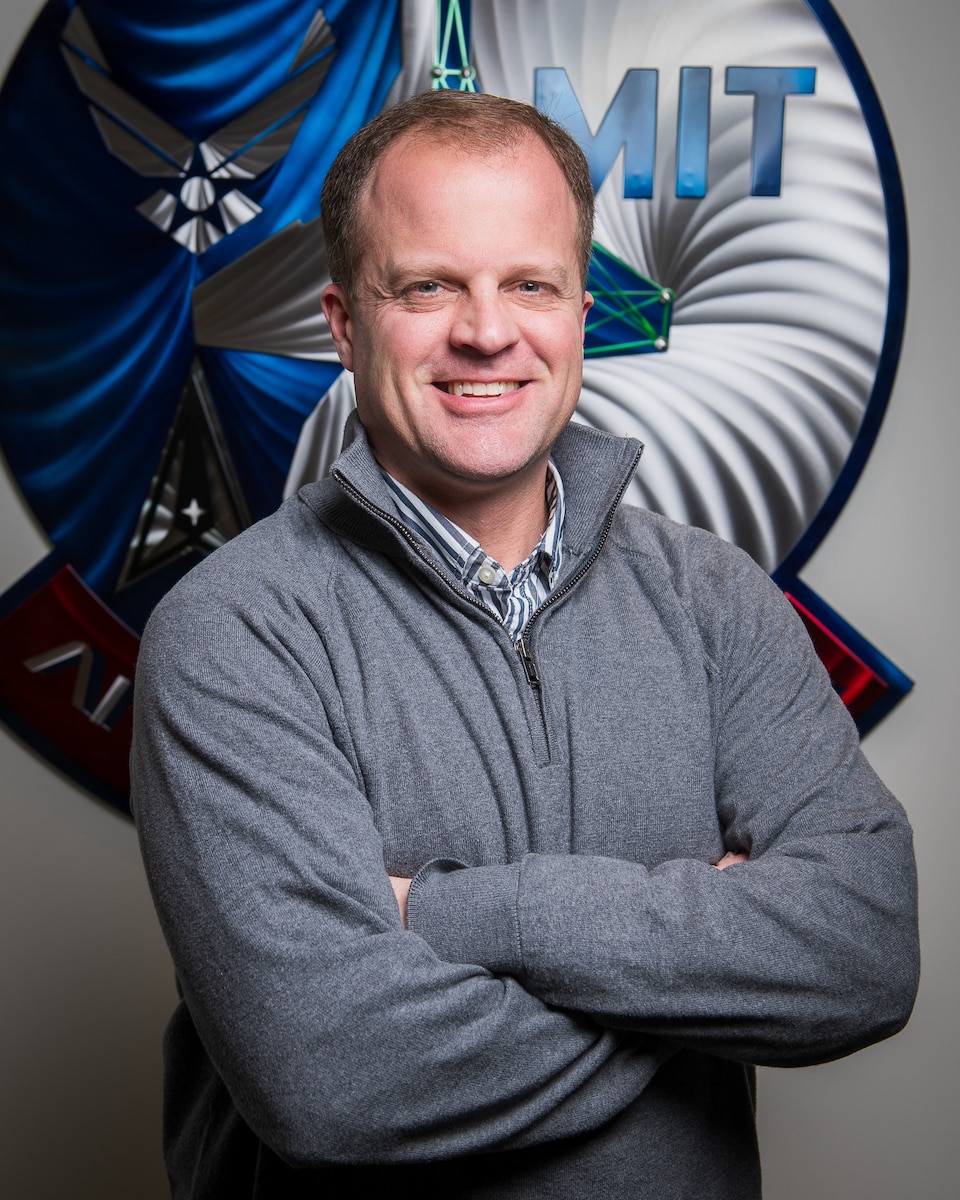 U.S. Air Force Colonel Garry Floyd, Director, DAF-MIT Artificial Intelligence Accelerator (AIA), poses for a photo at the AIA office, Cambridge, Mass., April 6, 2023. The AI Accelerator leverages universities, small businesses, traditional defense, and non-traditional commercial ventures, collaborating with the Air Force and Space Force to develop and ensure the ethical use of AI technologies for society and the nation. (U.S. Air Force photo by Tech. Sgt. Brycen Guerrero)