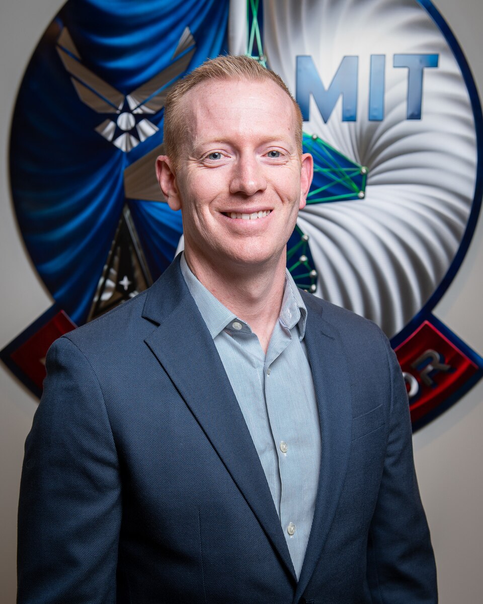 U.S. Air Force Major Joshua Rountree, Director of Operations, DAF-MIT Artificial Intelligence Accelerator (AIA), poses for a photo at the AIA office, Cambridge, Mass., April 6, 2023. The AI Accelerator leverages universities, small businesses, traditional defense, and non-traditional commercial ventures, collaborating with the Air Force and Space Force to develop and ensure the ethical use of AI technologies for society and the nation. (U.S. Air Force photo by Tech. Sgt. Brycen Guerrero)