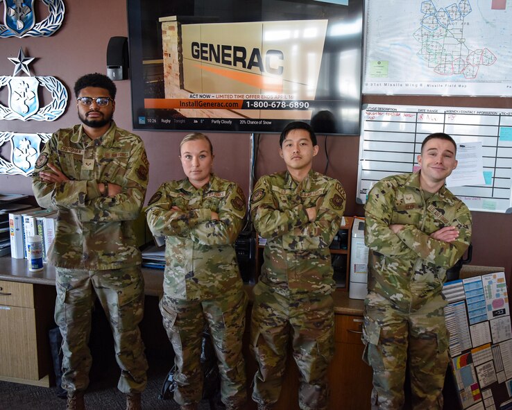 Senior Airman Christina Long, 5th Operations Support Squadron weather forecaster (center left), poses for a photo with her team at Minot Air Force Base, North Dakota, April 7, 2023. A weather Airman’s duties primarily involve integrating current and forecasted atmospheric and space weather conditions into operations and planning.  (U.S. Air Force photo by Senior Airman Caleb S. Kimmell)