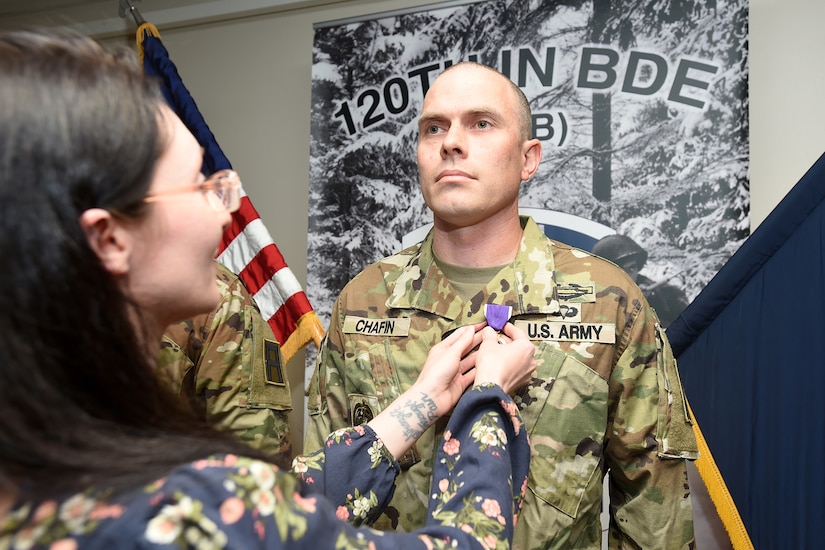 U.S. Army Reserve Master Sgt. Daniel Chafin, Mobilization Demobilization Operations Center Noncommissioned Officer in Charge, 2-360th Training Support Battalion, is pinned with a Purple Heart by his wife Rachel, April 05, 2023, at First Army Division West headquarters on Fort Hood, Texas.