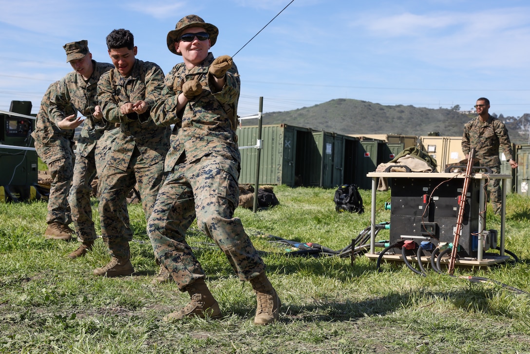 U.S. Marines with I Marine Expeditionary Force Information Group pull camouflage netting over a tent during a mini exercise on Marine Corps Base Camp Pendleton, California, Feb. 10, 2023. The mini exercise was conducted to familiarize Marines with equipment, tactical convoy training and battalion tactical standard operating procedures in preparation for Exercise Balikatan 2023. (U.S. Marine Corps photo by Sgt. Anabel Abreu Rodriguez)