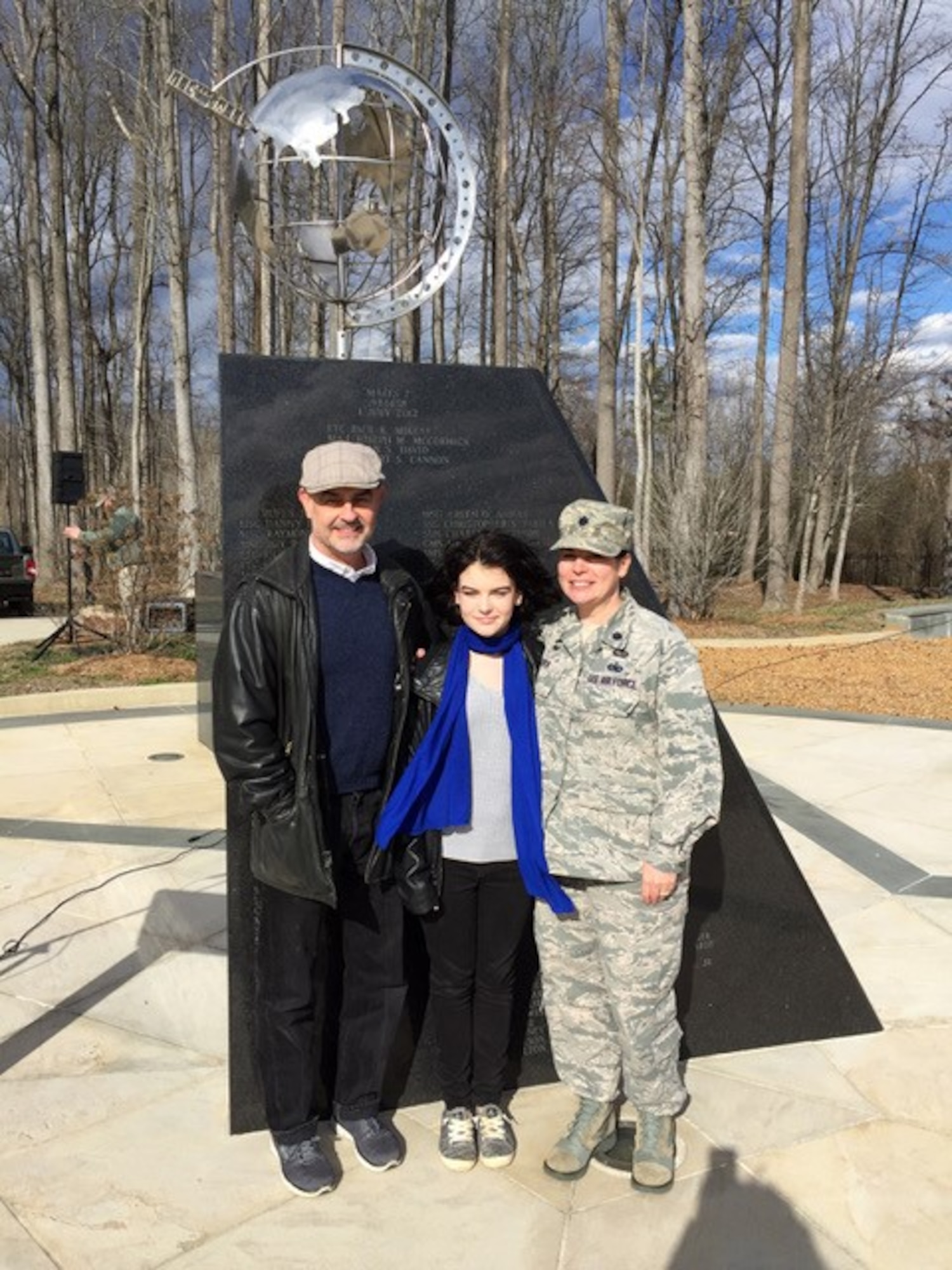 The new vice commander of the 145th Airlift Wing poses for a photo with her family, in front of the memorial site on base.