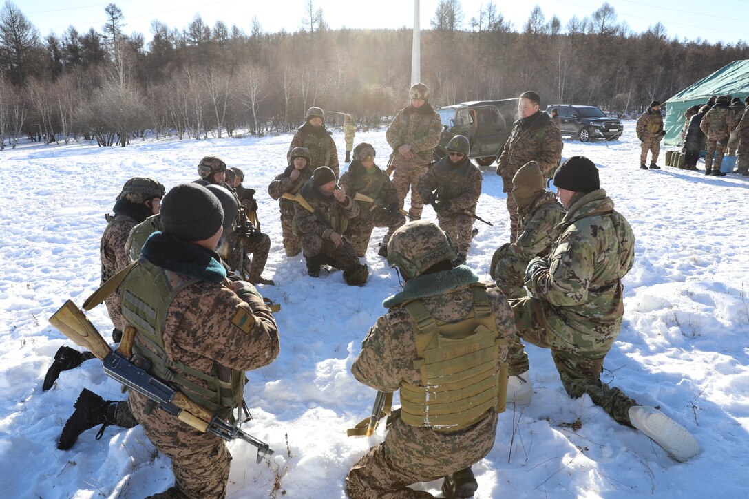 Advisors from 5th SFAB, Sgt. 1st Class Albert Jacques and Sgt. 1st Class Lester Reed lead an After Action Review with a Mongolian squad during a field training exercise for peacekeeping training in Mongolia, Winter 2022-2023.