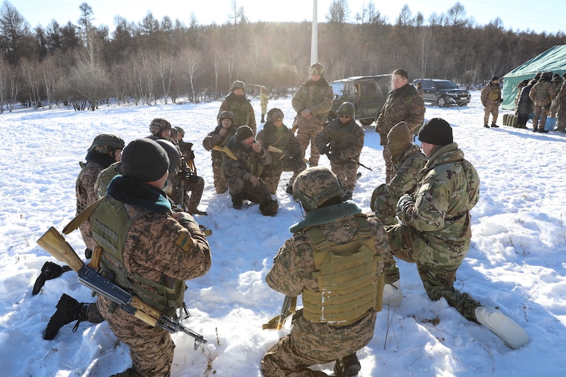 Advisors from 5th SFAB, Sgt. 1st Class Albert Jacques and Sgt. 1st Class Lester Reed lead an After Action Review with a Mongolian squad during a field training exercise for peacekeeping training in Mongolia, Winter 2022-2023.
