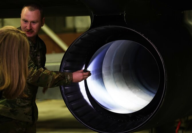 U.S. Air Force 9th Aircraft Maintenance Squadron airframe and powerplant general technician shines a flashlight to display the aircraft exhaust system of a U-2 Dragon Lady to 55th Wing key spouses, March 29, 2023, at Offutt Air Force Base, Nebraska.