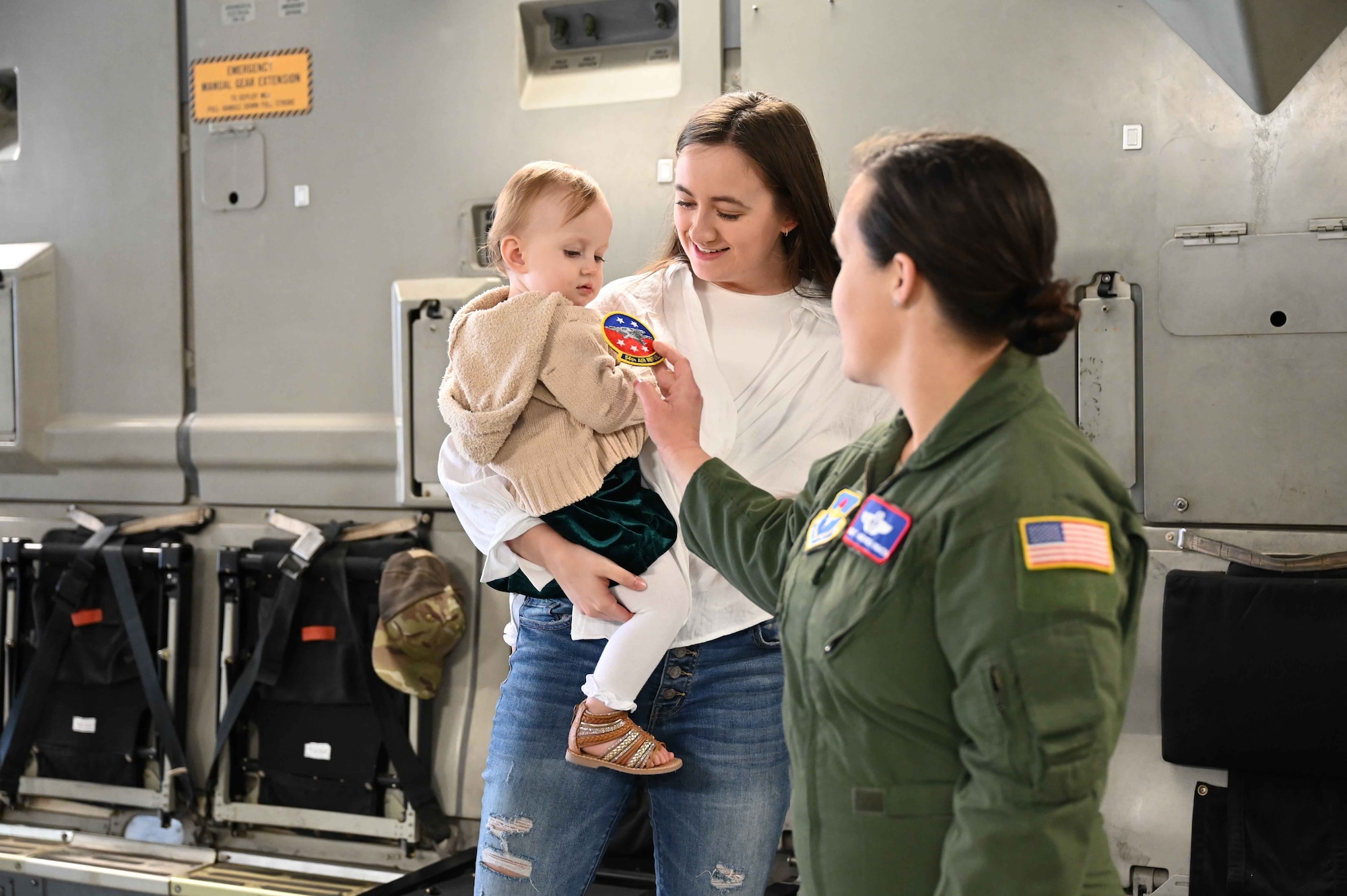 U.S. Air Force Chief Master Sgt. Andrea Inmon, 54th Air Refueling Wing senior enlisted leader, gifts her patch to the child of Technical Sgt. Brandon Walker, a graduate from the Basic Loadmaster Course at Joint Base San Antonio-Lackland (JBSA-Lackland), Texas, April 6, 2023.Several Altus Air Force Base, Oklahoma, leaders made the trip to JBSA-Lackland to welcome the graduates onto the aircraft in which many of them will be working with in the future. (U.S. Air Force photo by Airman 1st Class Kari Degraffenreed)