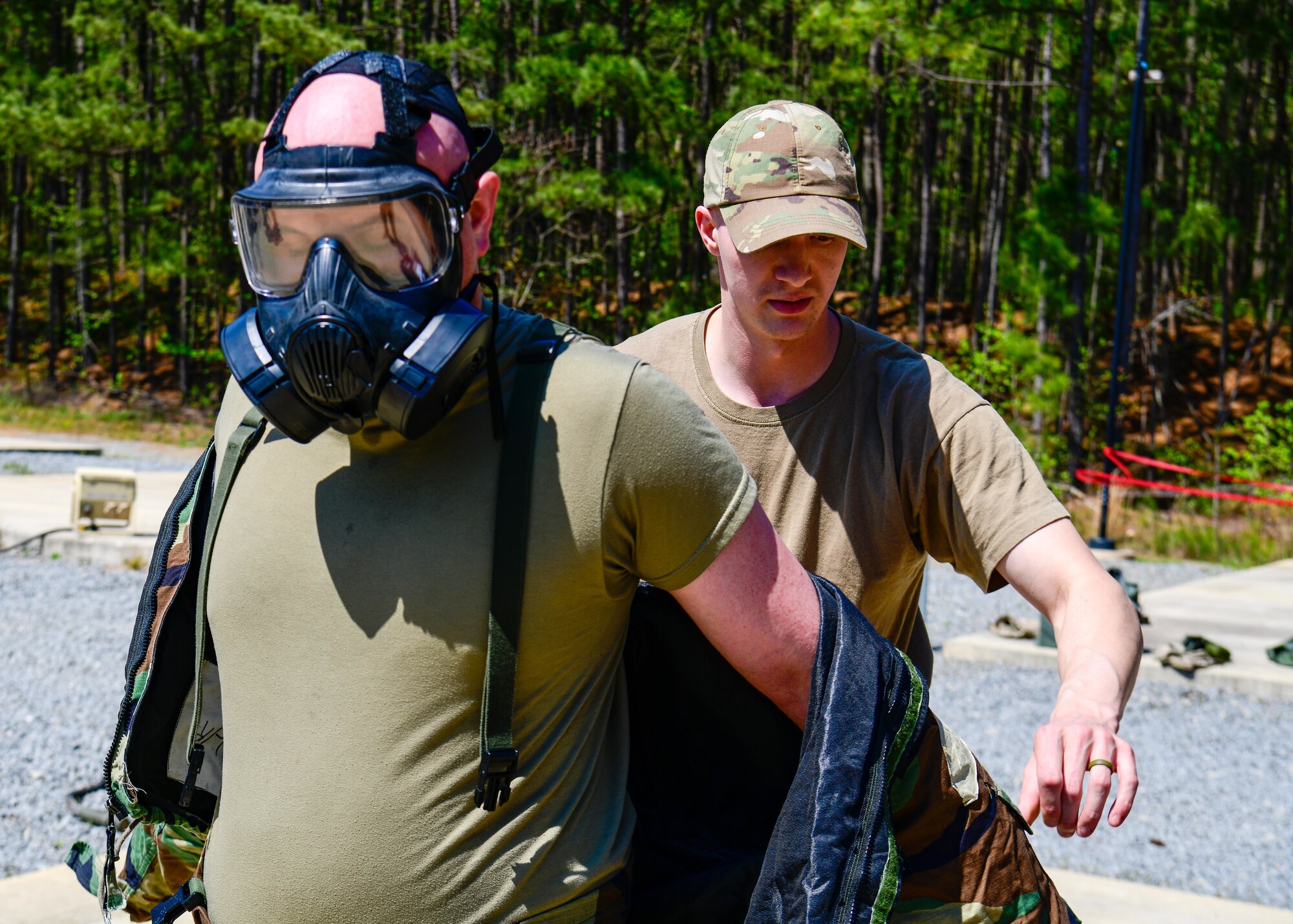 Senior Airman Brandon Strachan, an HVAC helper with the 910th Civil Engineer Squadron, has his mission-oriented protective posture gear removed by Tech. Sgt. Donald Duda, an emergency management journeyman with the 910th CES, March 30, 2023, at Dobbins Air Reserve Base, Georgia.