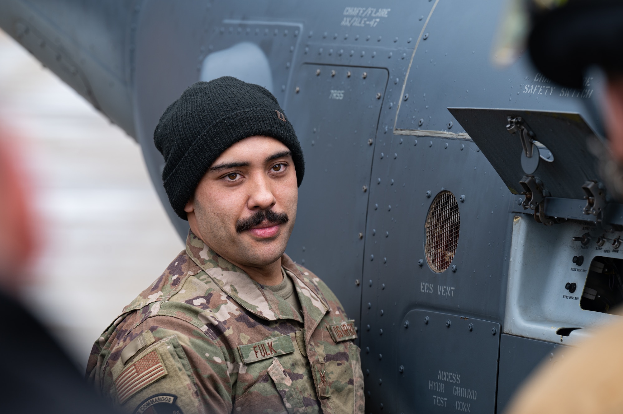 U.S. Air Force Staff Sgt. Roger Fulk, 352nd Special Operations Wing CV-22B Osprey aircraft crew chief, explains to 100th Civil Engineer Squadron firefighters the procedure for opening a CV-22B rear door, after extinguishing a simulated fire, March 31, 2023, at Royal Air Force Mildenhall, England.