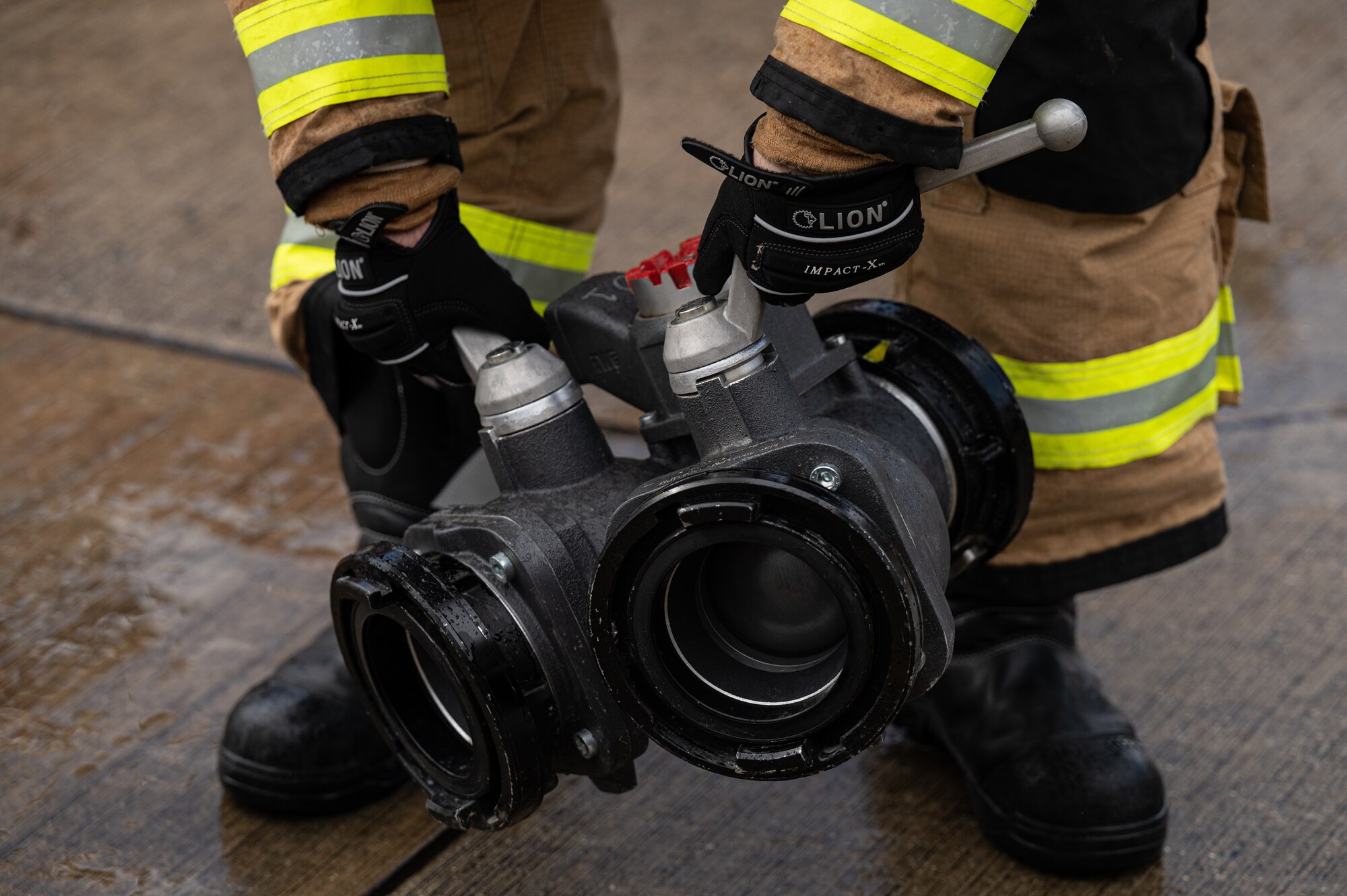 A 100th Civil Engineer Squadron firefighter, picks up a manifold after extinguishing a simulated fire of a CV-22B Osprey aircraft assigned to the 352nd Special Operations Wing, March 31, 2023, at Royal Air Force Mildenhall, England.