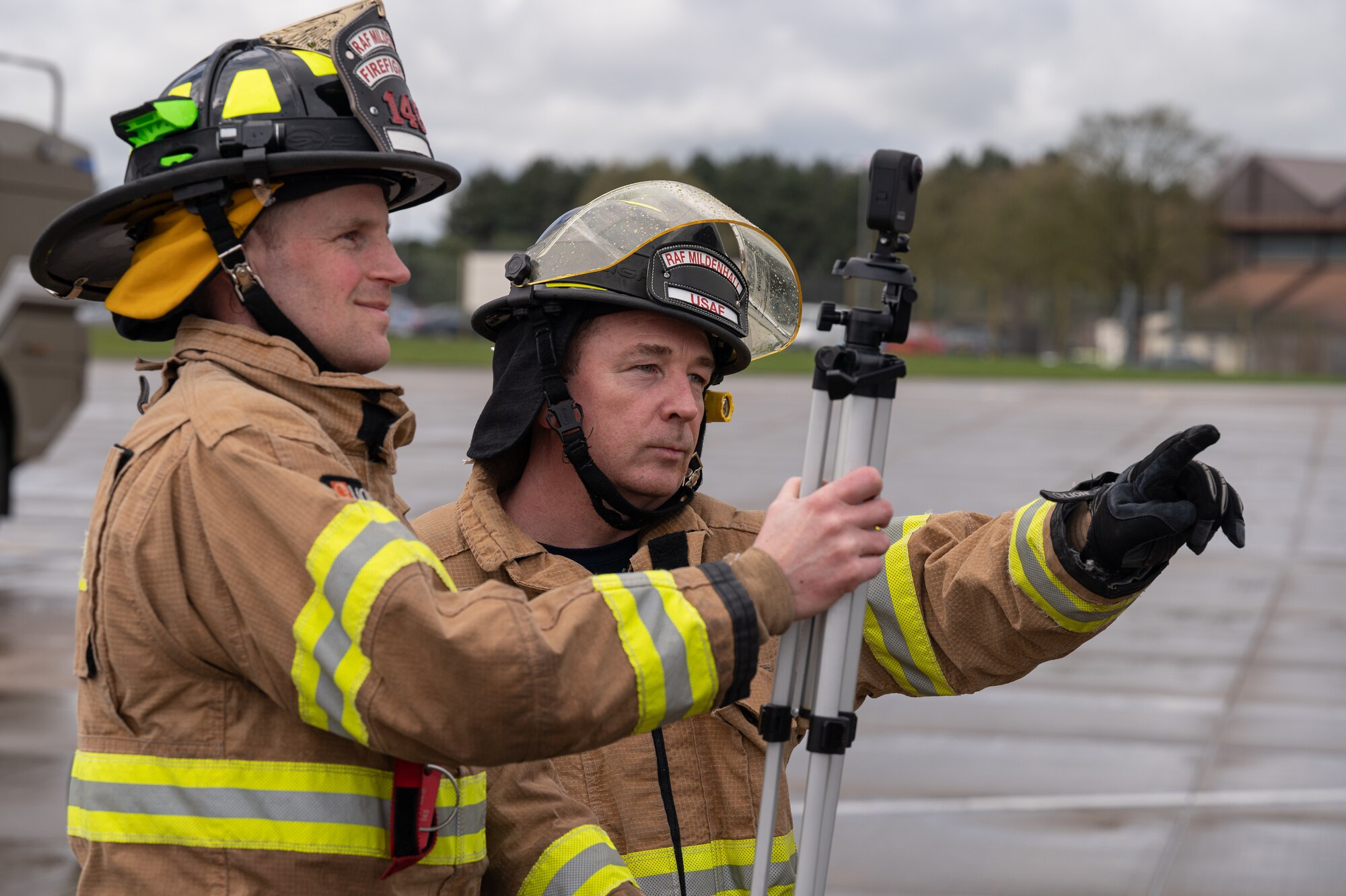 Mark Matless, left, and Paul Oakes, right, both 100th Civil Engineering Squadron firefighters, record the scene of a simulated fire of a CV-22B Osprey aircraft assigned to the 352nd Special Operations Wing, March 31, 2023, at Royal Air Force Mildenhall, England.
