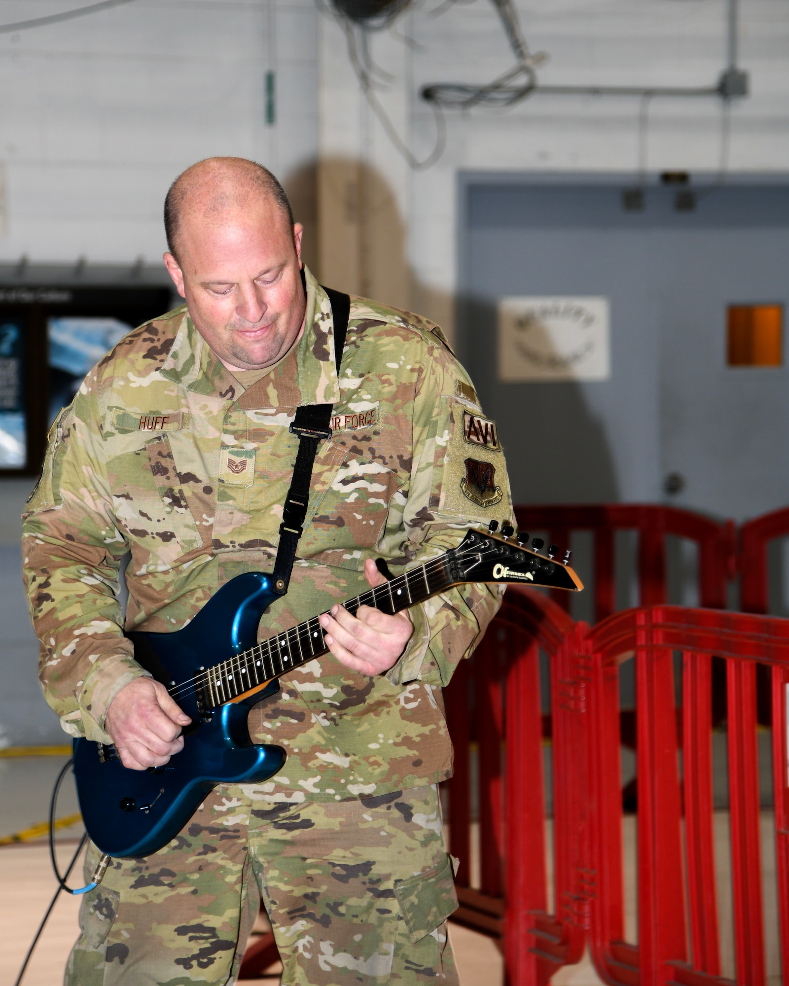 A photo of Tech. Sgt. Mark Huff, 177th Maintenance Squadron avionics technician, plays the U.S. national anthem on electric guitar.