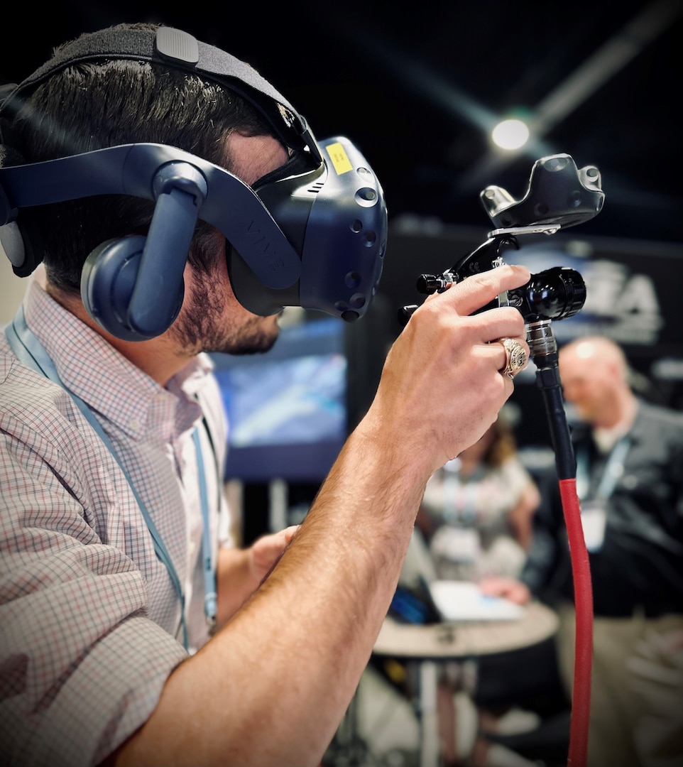 Naval Surface Warfare Center, Carderock Division engineer Dr. Lee Huntington demonstrates how to use the virtual painter system during the 2023 Sea-Air-Space Exposition in National Harbor, Md., on April 4. (U.S. Navy photo by Monica McCoy)