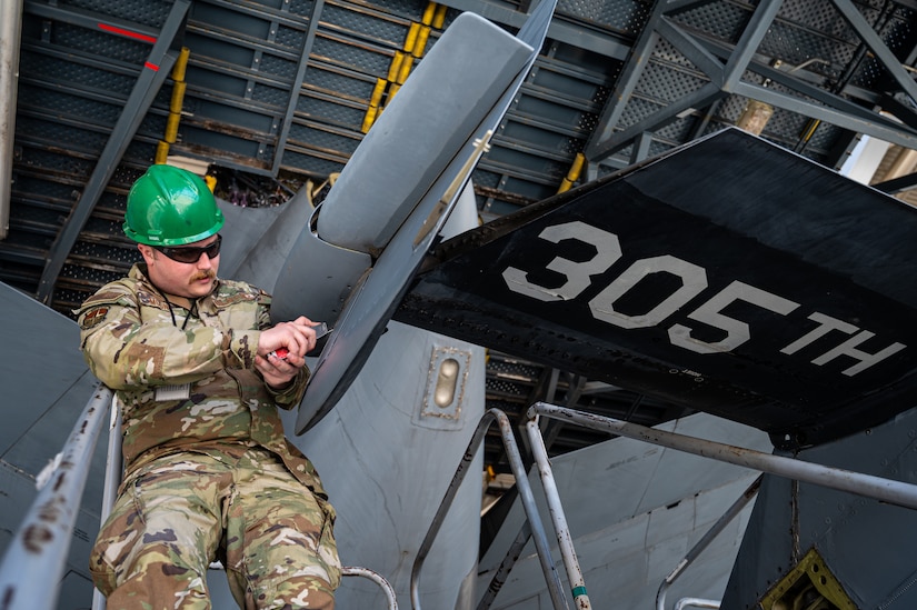 U.S. Air Force Senior Airman Austin Mooney, 305th Maintenance Squadron crew chief, removes a panel during the final KC-10 Extender inspection at Joint Base McGuire-Dix-Lakehurst, N.J., April 10, 2023.