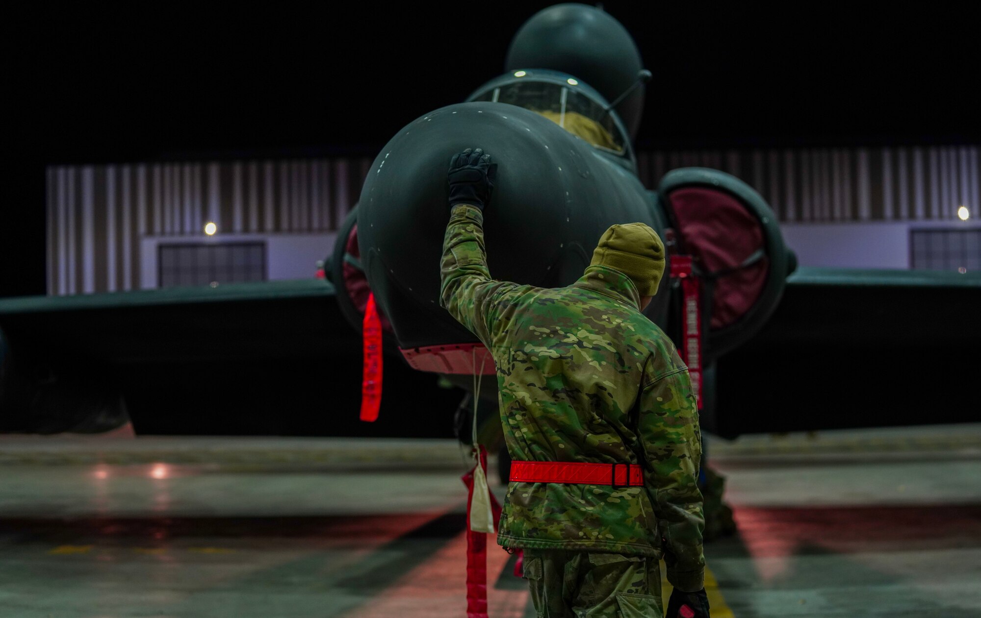 A U.S. Air Force 9th Aircraft Maintenance Squadron electrical and environmental systems craftsman guides a U-2 Dragon Lady into a hangar following an evening flight in support of Dragon Flag EAST, April 1, 2023, at Offutt Air Force Base, Nebraska.