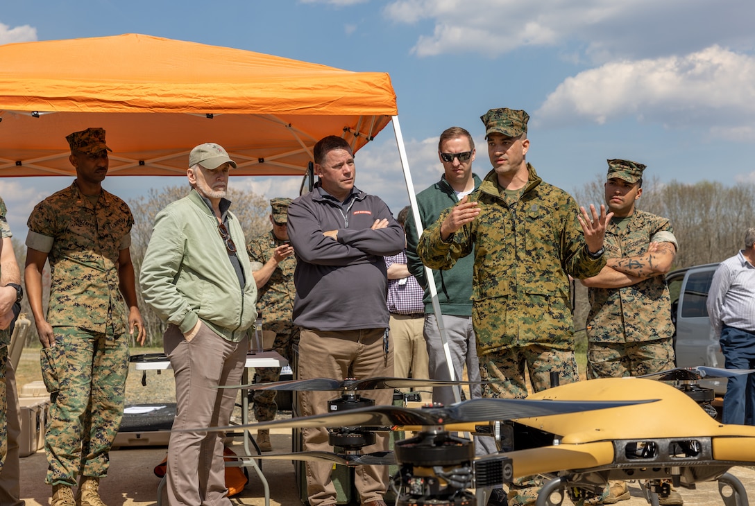 U.S. Marine Corps Master Sgt. Christopher D. Genualdi, capabilities integration officer, Logistical Combat Element Integration Division, Capabilities Development Directorate, Combat Development and Integration, speaks during a demonstration at DZ Cockatoo on Marine Corps Base Quantico, Virginia, March 29, 2023. Combat Development and Integration demonstrated the Tactical Resupply Unmanned Aircraft System, programming the Unmanned Logistics Systems-Air to carry a payload over a short distance, drop it at a specified location in the landing zone and return to its staring point. The TRUAS has a 9-mile range and maximum payload of 150 pounds, which is sufficient to fly in ammunition, food, medical supplies, and batteries, among other supplies. This small system only requires two Marines to operate and will be a game-changing capability for our distributed forces. Fielding this capability is a critical step in setting conditions for the development of the ULS-A Medium system, which is the required capability for large-scale tactical distribution in a contested space.